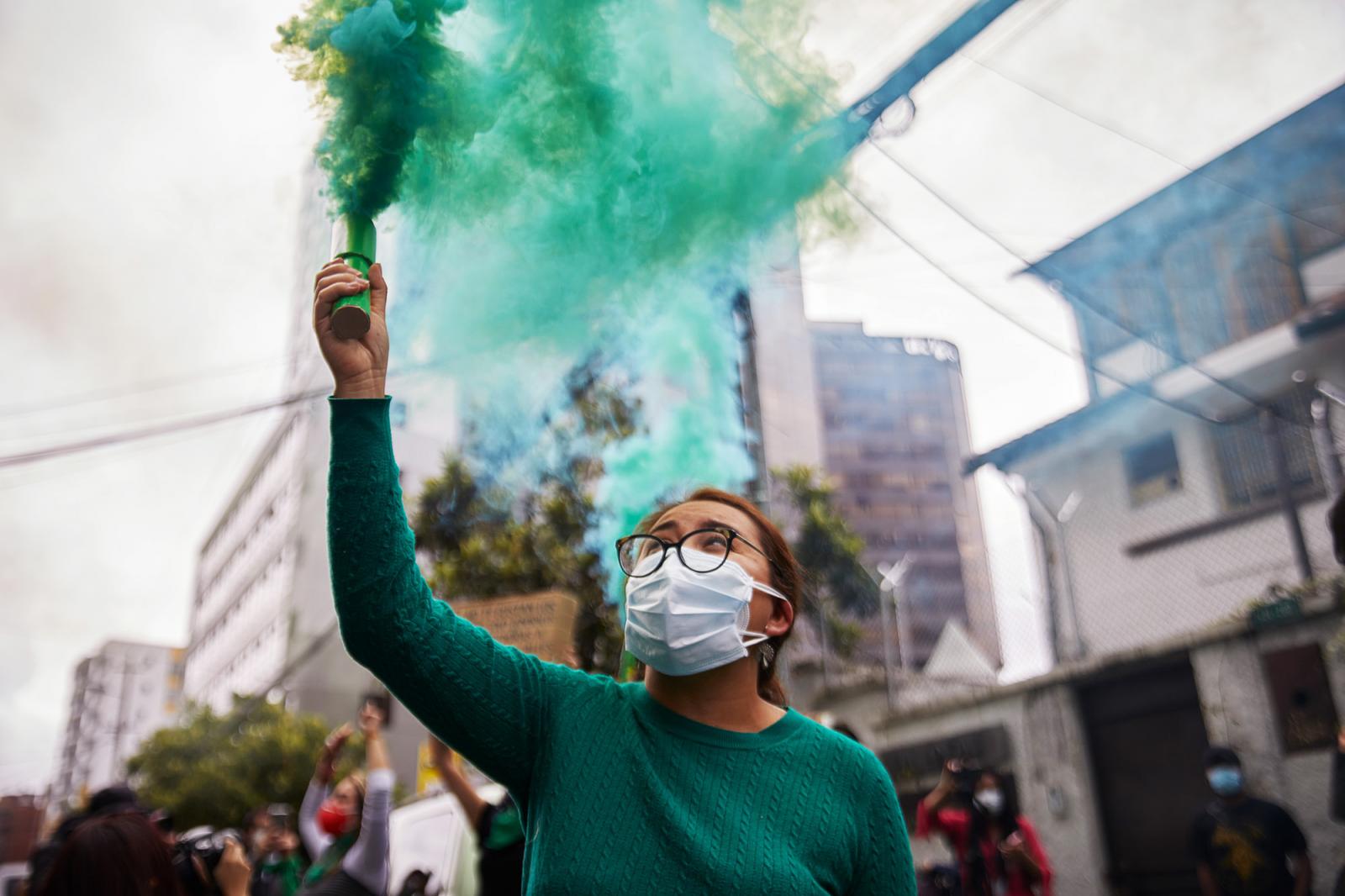 A woman holds a flare after the...April 28, 2021, Quito, Ecuador.