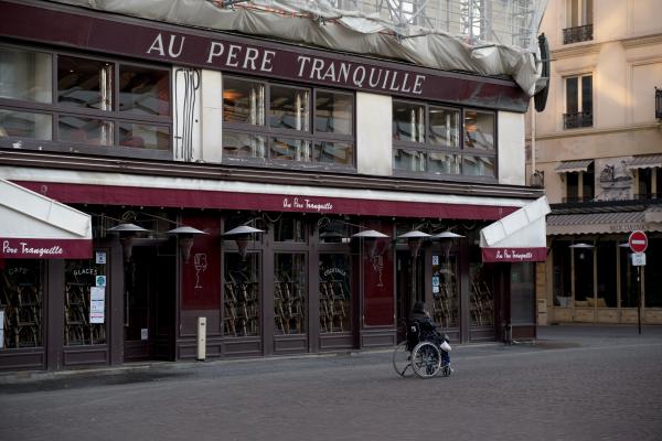  Un homme en fauteuil roulant t&eacute;l&eacute;phone, devant le restaurant Au p&egrave;re tranquille. Pendant le confinement, Ch&acirc;telet, &agrave; Paris, le 06.11.2020.&nbsp; 