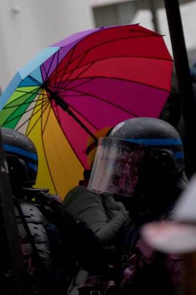 Le parapluie de Moun, figure du rassemblement contre les violences polici&egrave;res croise un policier. Boulevard Gambetta, Paris, d&eacute;cembre 2020.