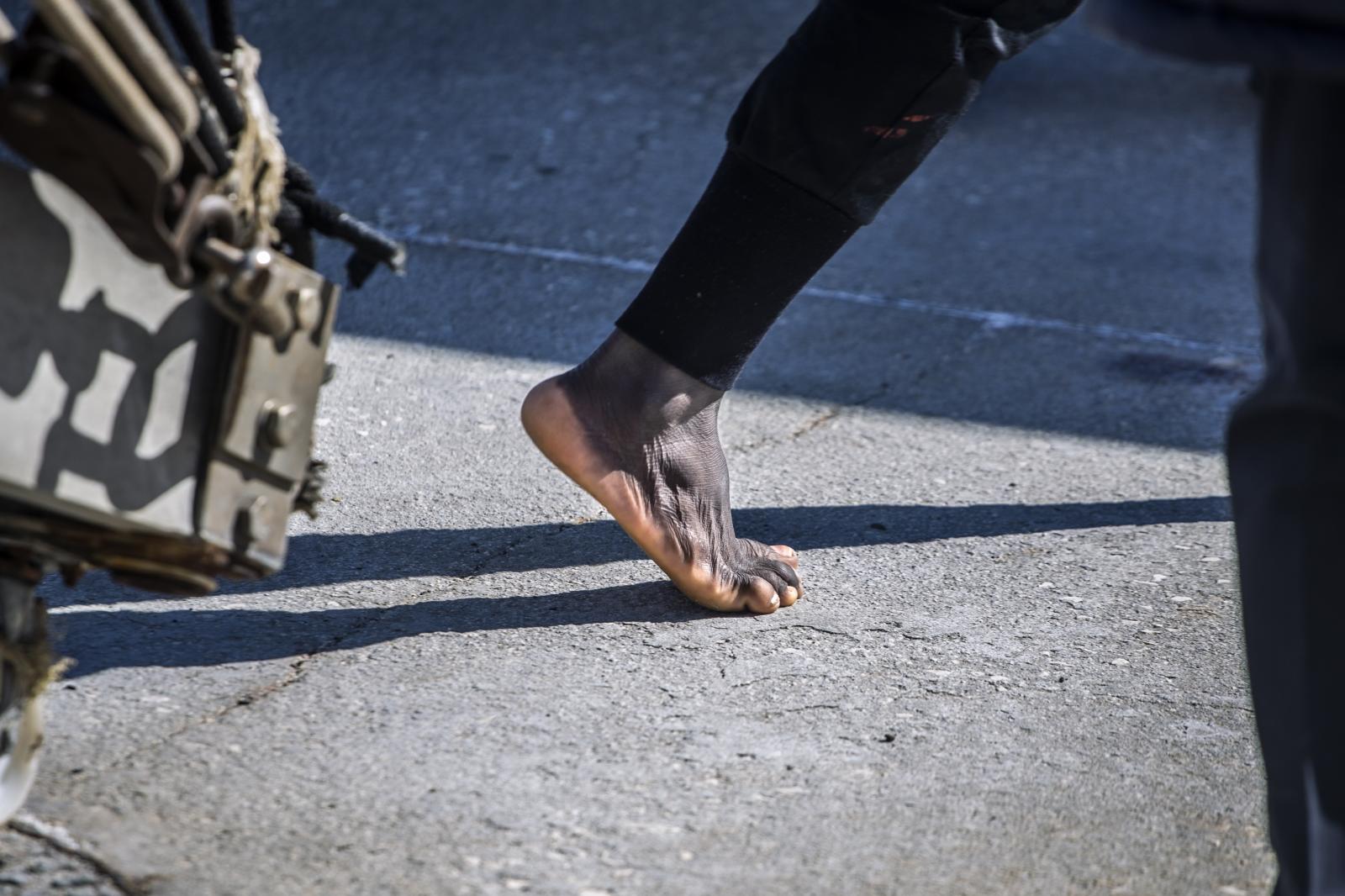 Fleeing the Libyan Clutches - A migrant steps on the ground barefoot in the Italian...