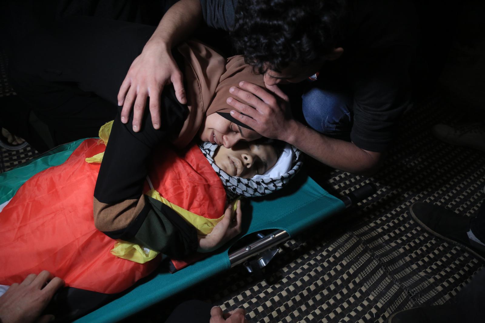 Nagham Tolba embraces killed the corpse of her 15-year-old brother, Mahmoud Tolba, who was killed...