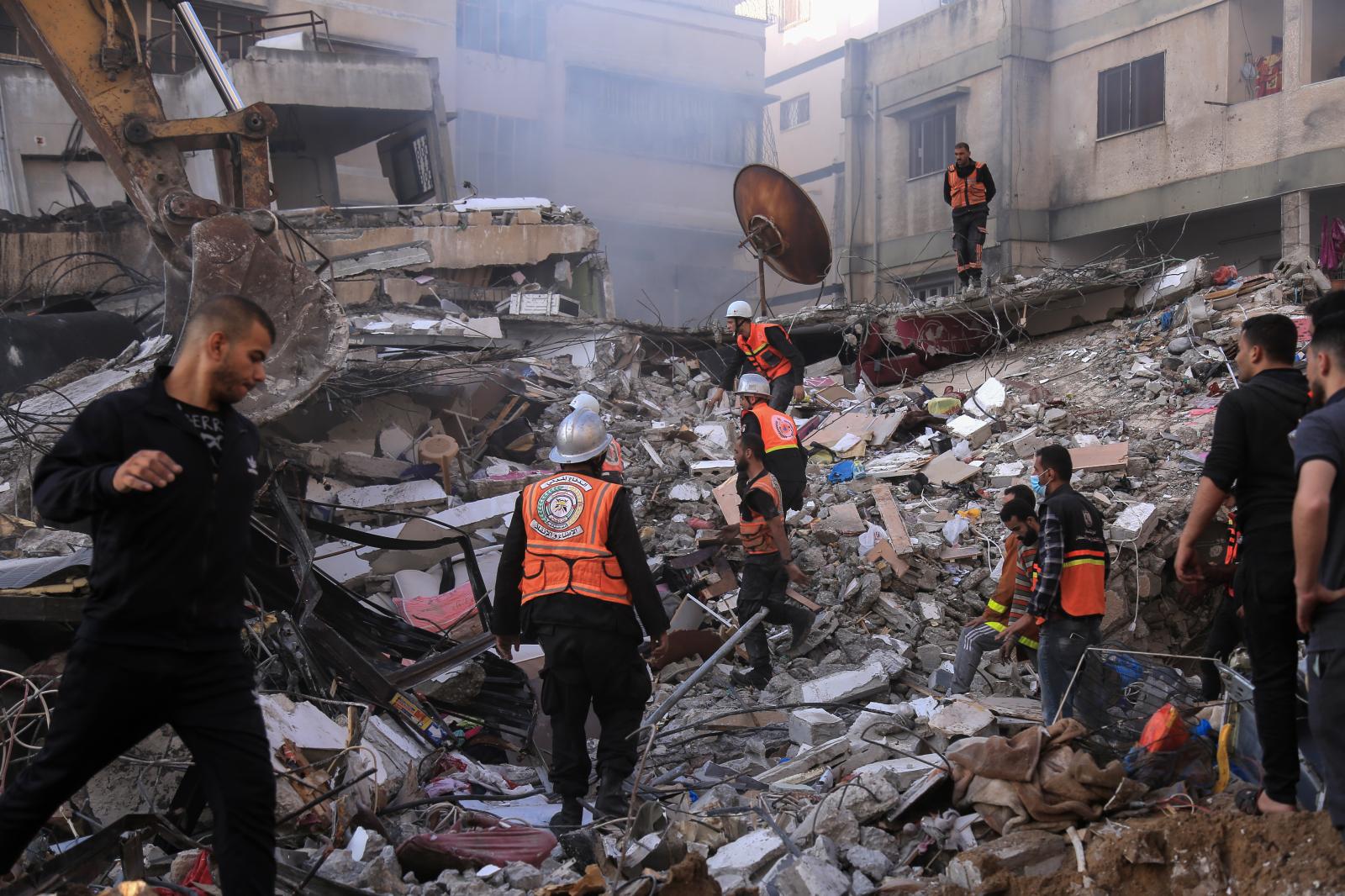 Civil Defense men search for children and women under the rubble after an Israeli plane bombed an...