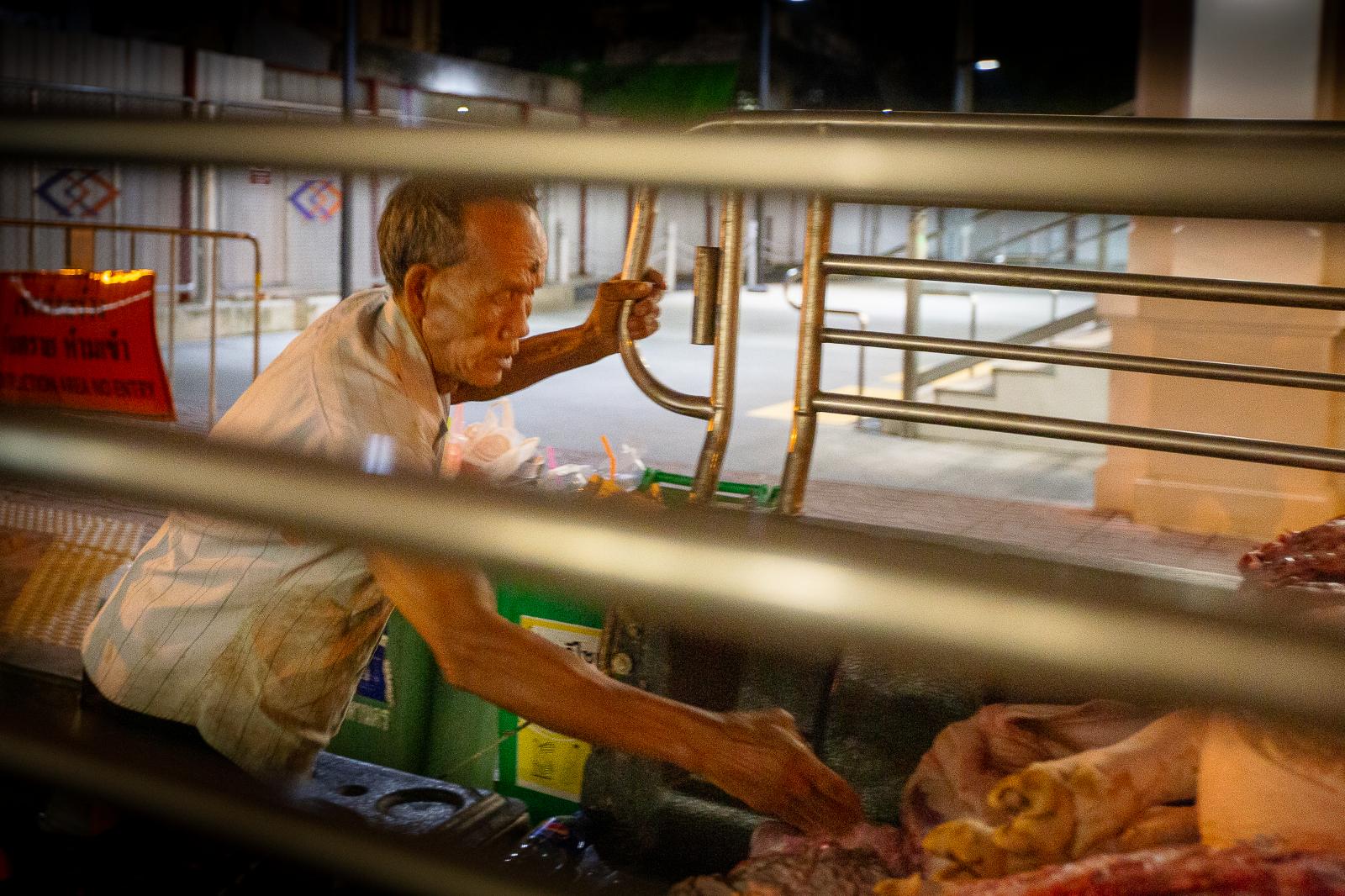 Unloading pig carcasses in front of a subway station