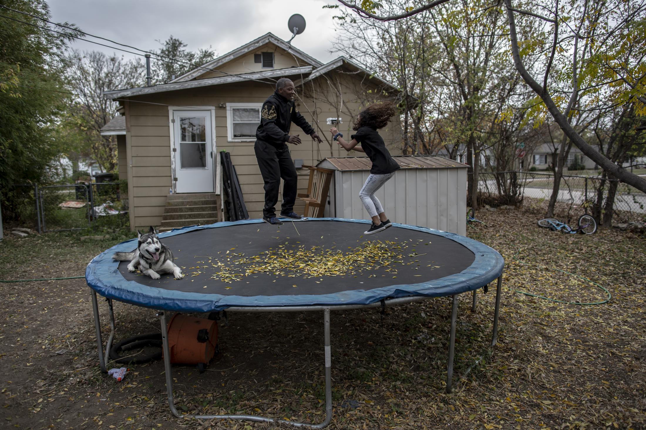 Growing From Tradition - Tony Crawford plays with his family on a trampoline in...