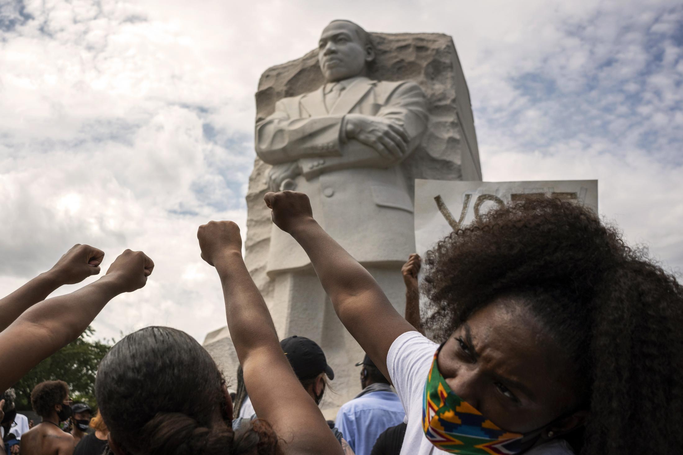 Singles - Black women raise their fists in front of the MLK...