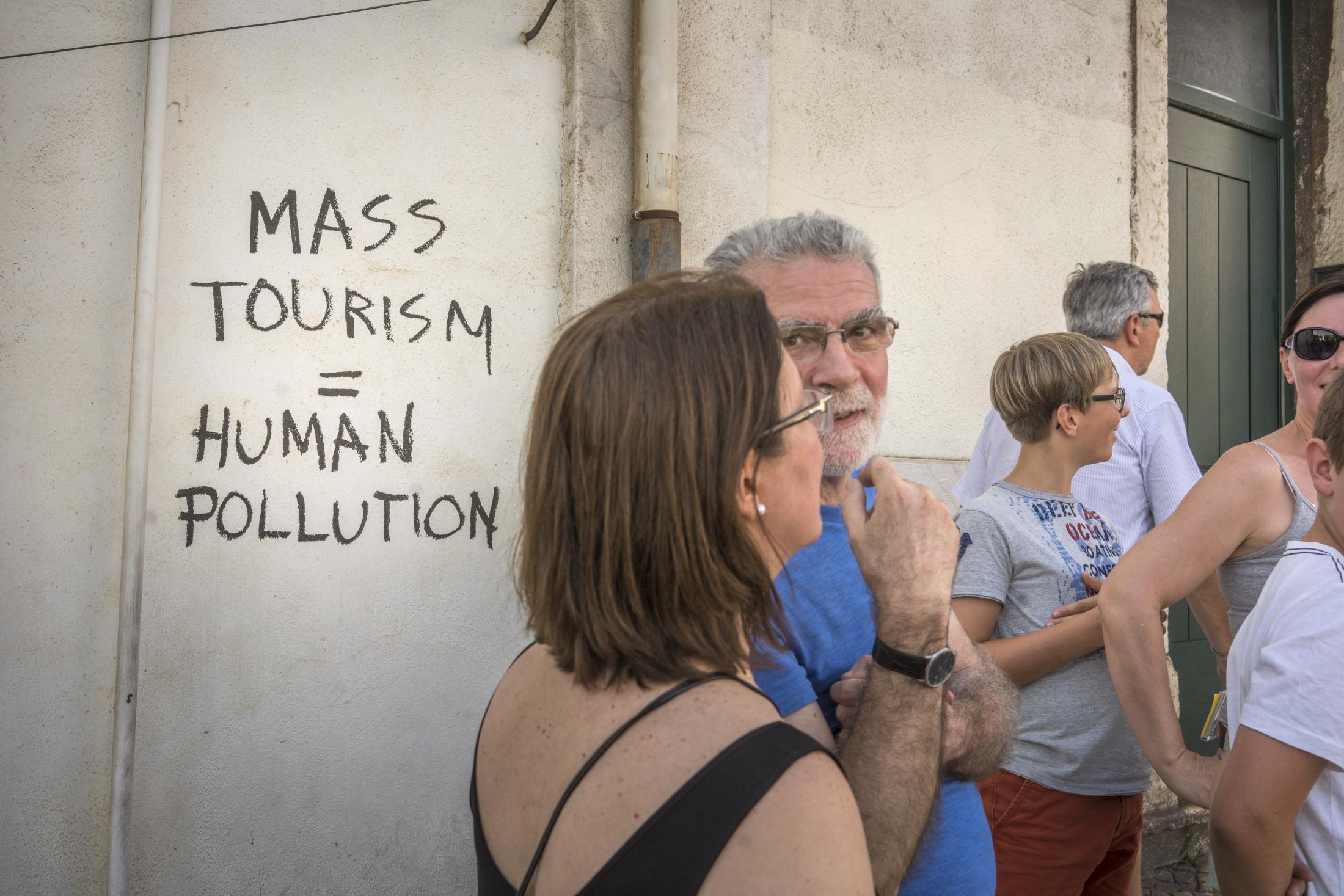 Lisbon - Anti-tourism grafitti on a wall in Alfama, a historic...