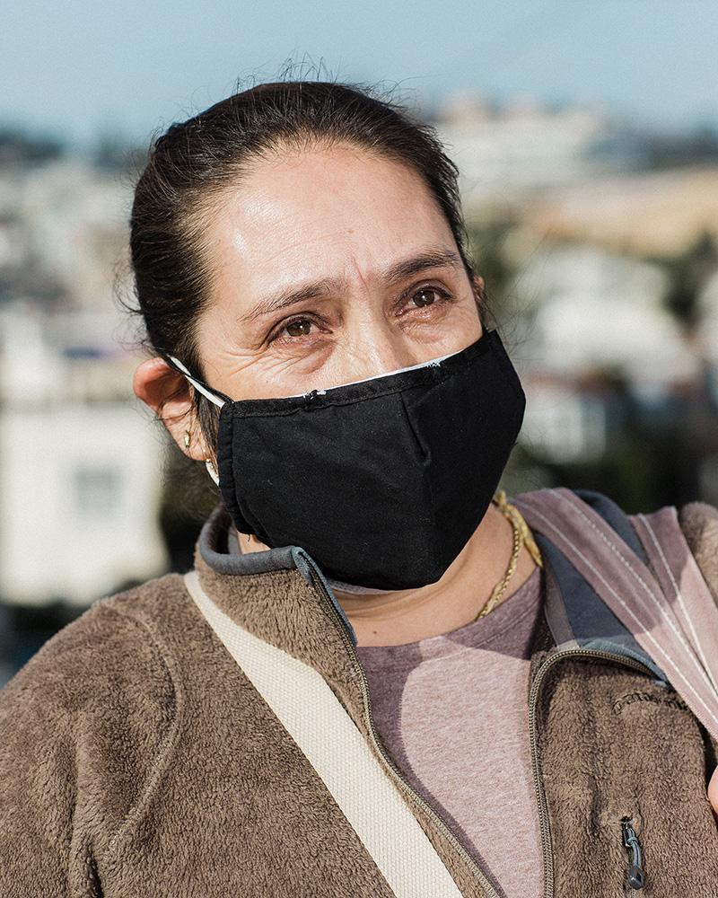 Housing War on The Water - Maria Teresa Palacio stands for a portrait after waiting in line to receive food aid and just...