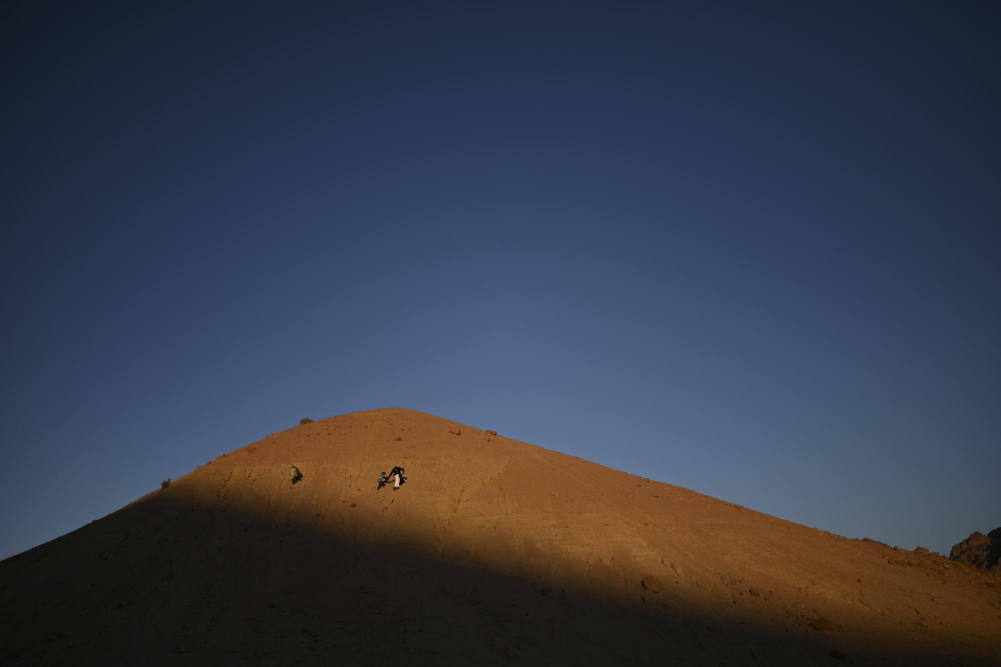 On National Geographic: In one of Egypt's most spiritual places, Bedouins find peace and resilience - A father and son walk over the hill to watch the last moments of sunset. Fathers within the...