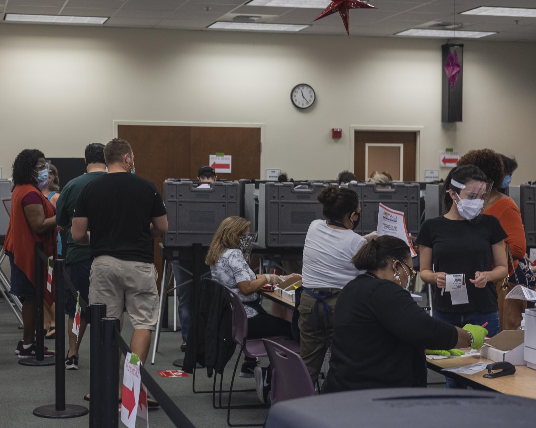  Early voters waiting their turn to vote and checking in with poll workers inside of the Broward County Library Weston Branch - an early voting location.&nbsp; Weston, Fl. November 3, 2020.&nbsp; Credit: Andr&eacute;s Guerrero 