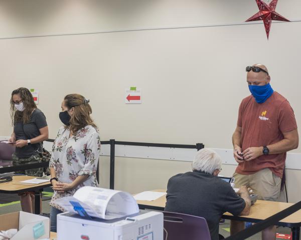 Weston, Fl &ndash; October 29, 2020: Early voters checking in with poll workers inside of the Broward County Library Weston Branch - an early voting location. Credit: Andres Guerrero