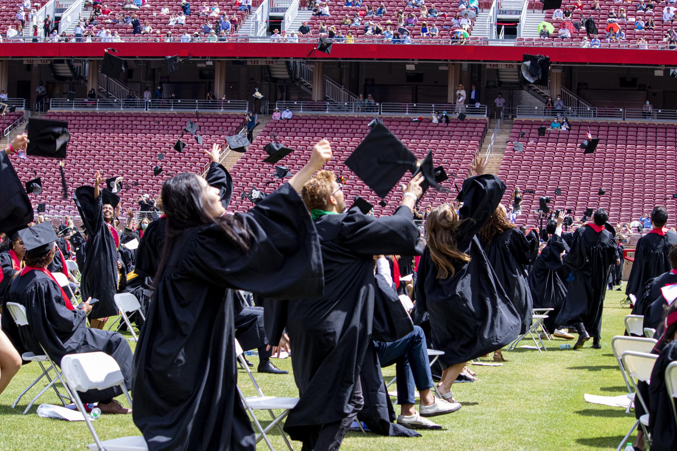 Graduation, at last (Photos for CalMatters) - Students throw their graduation caps into the air at Stanford University, in Palo Alto, Calif.,...