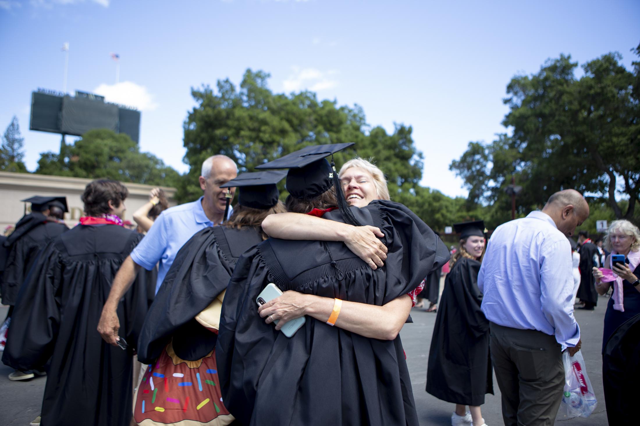 Graduation, at last (Photos for CalMatters) - A parent hugs her son and congratulates him after the graduation ceremony at Stanford University,...