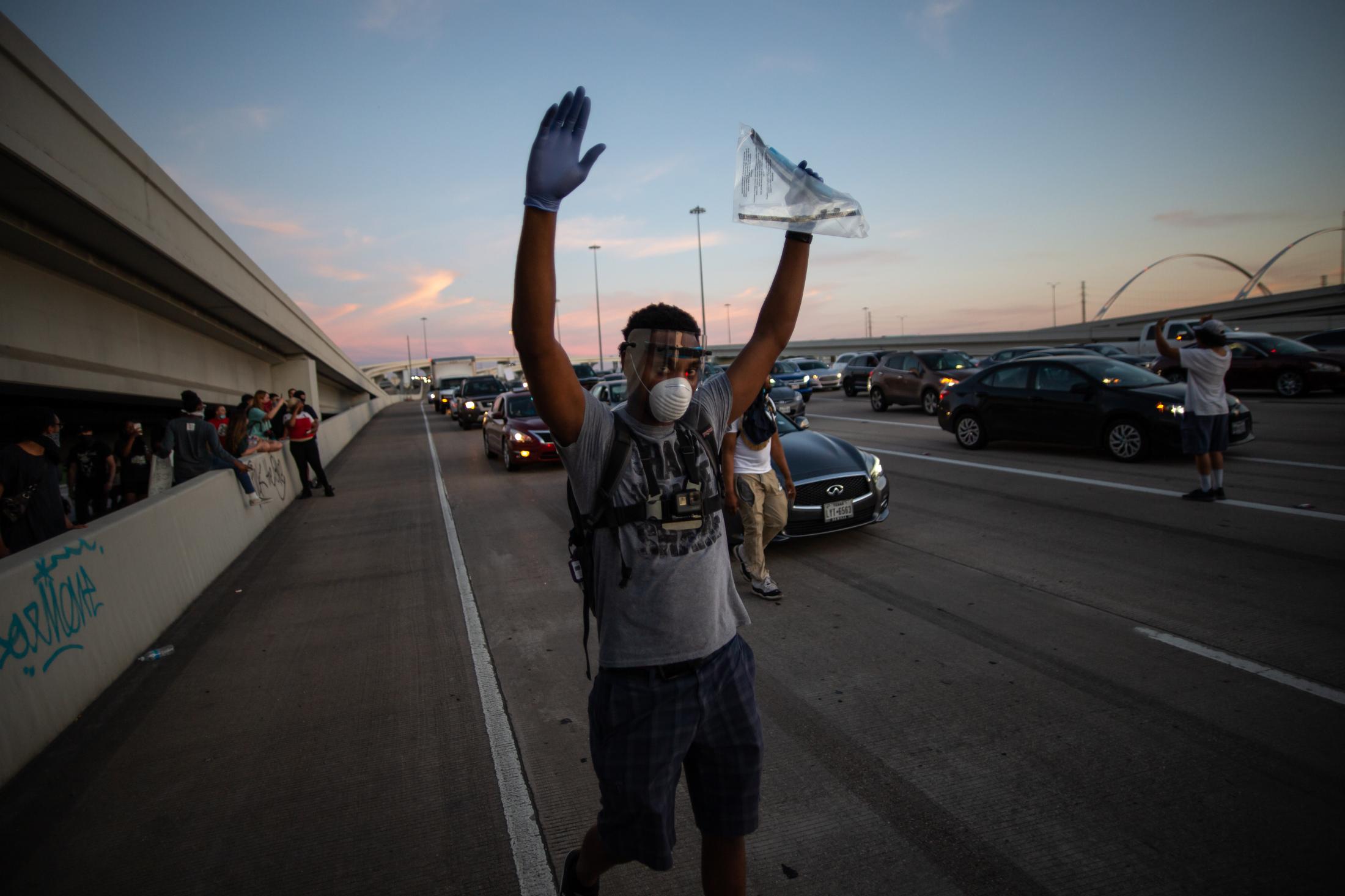 Unrest Dallas - A protestor walks onto Dallas Highway 35 East, as...