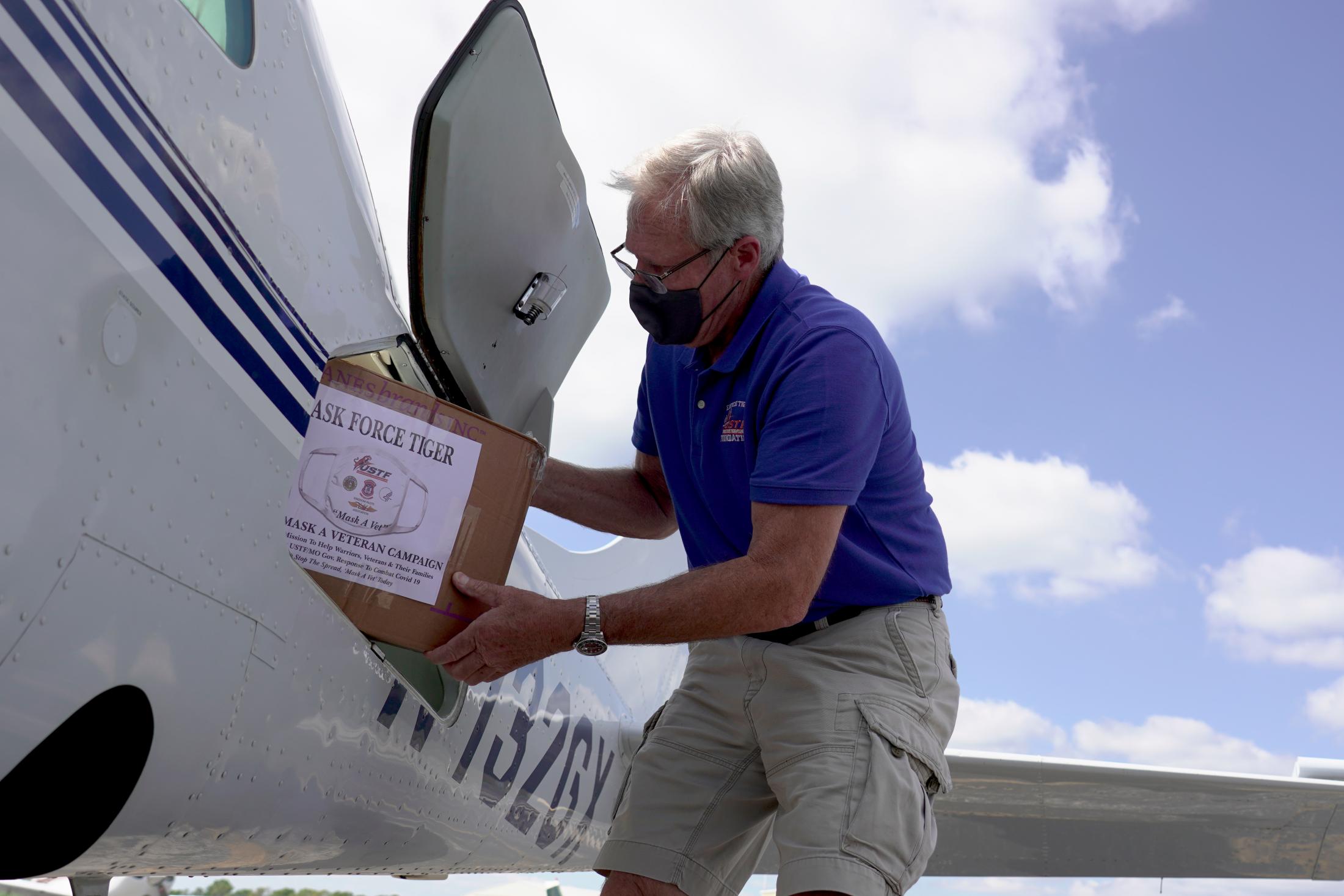 Help From Above - Steve Wendling loads boxes of masks into his plane for...