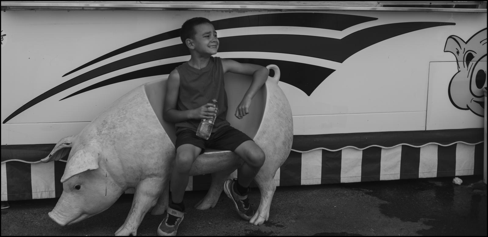 My Americana -  Young boy, hog seat, Minnesota State Fair, 2023. St....