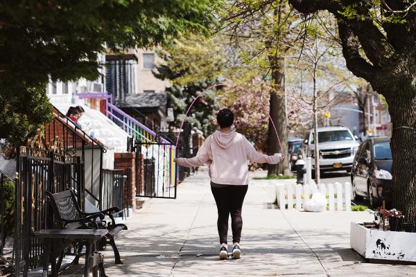 "New York is Back"? - Woman jumping rope on the sidewalk in front of her house. April 2020, Brooklyn.