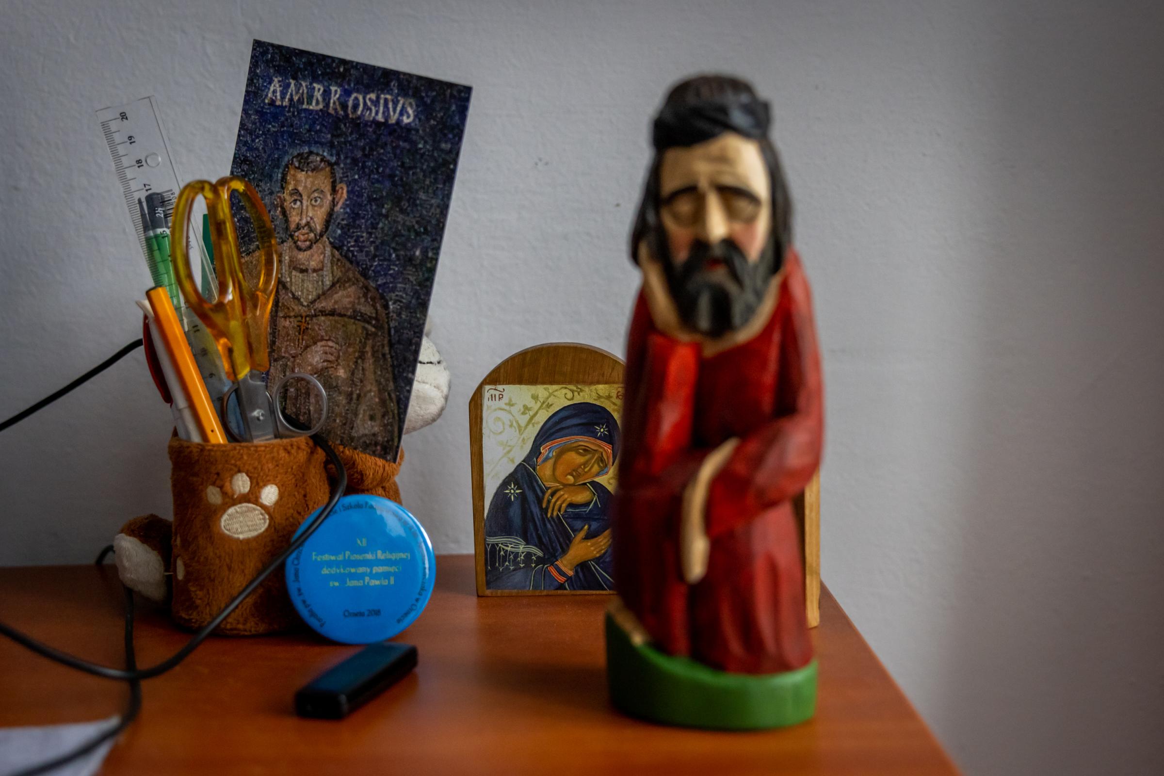 LONELY POLISH PRIEST -for NRC - Figurines of Saints on the desk in cleric Krzysztof...