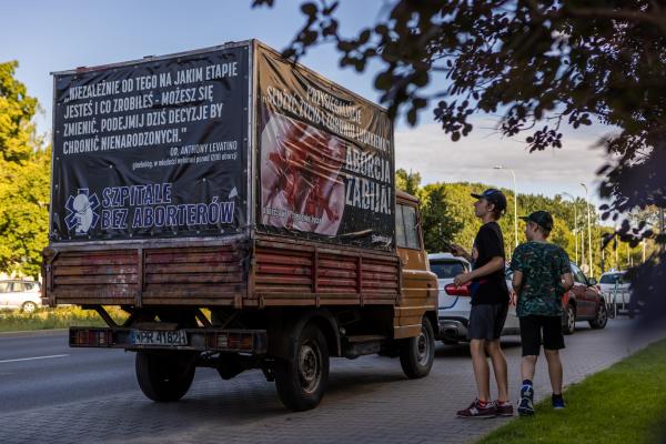 Image from "MY LIFE IS IN DANGER" - for NYTimes - A car with anti-abortion posters is parked at the Medical...