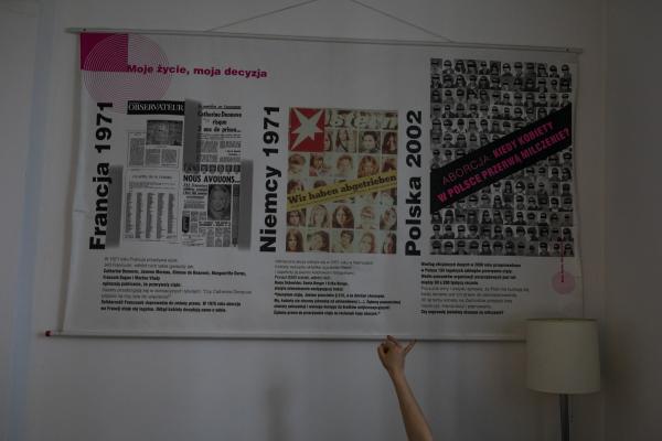 Image from "MY LIFE IS IN DANGER" - for NYTimes - Banner on the wall of the Federation for Women and Family...