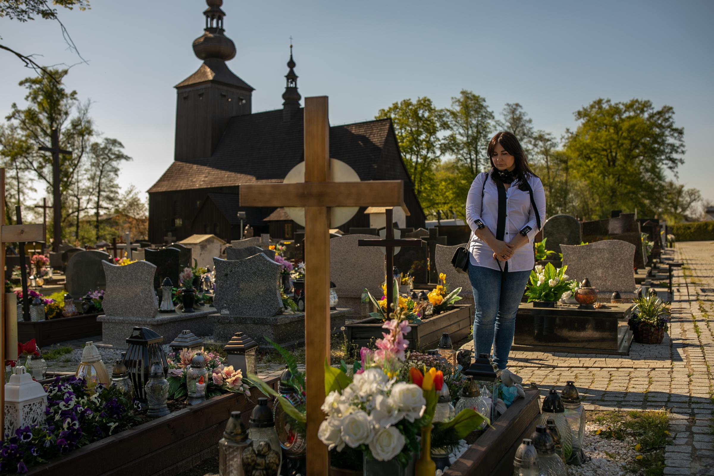 Barbara Skrobol visiting the grave of her sister-in-law Izabela Sajbor and her unborn child at a cemetery in Cwiklice, Poland