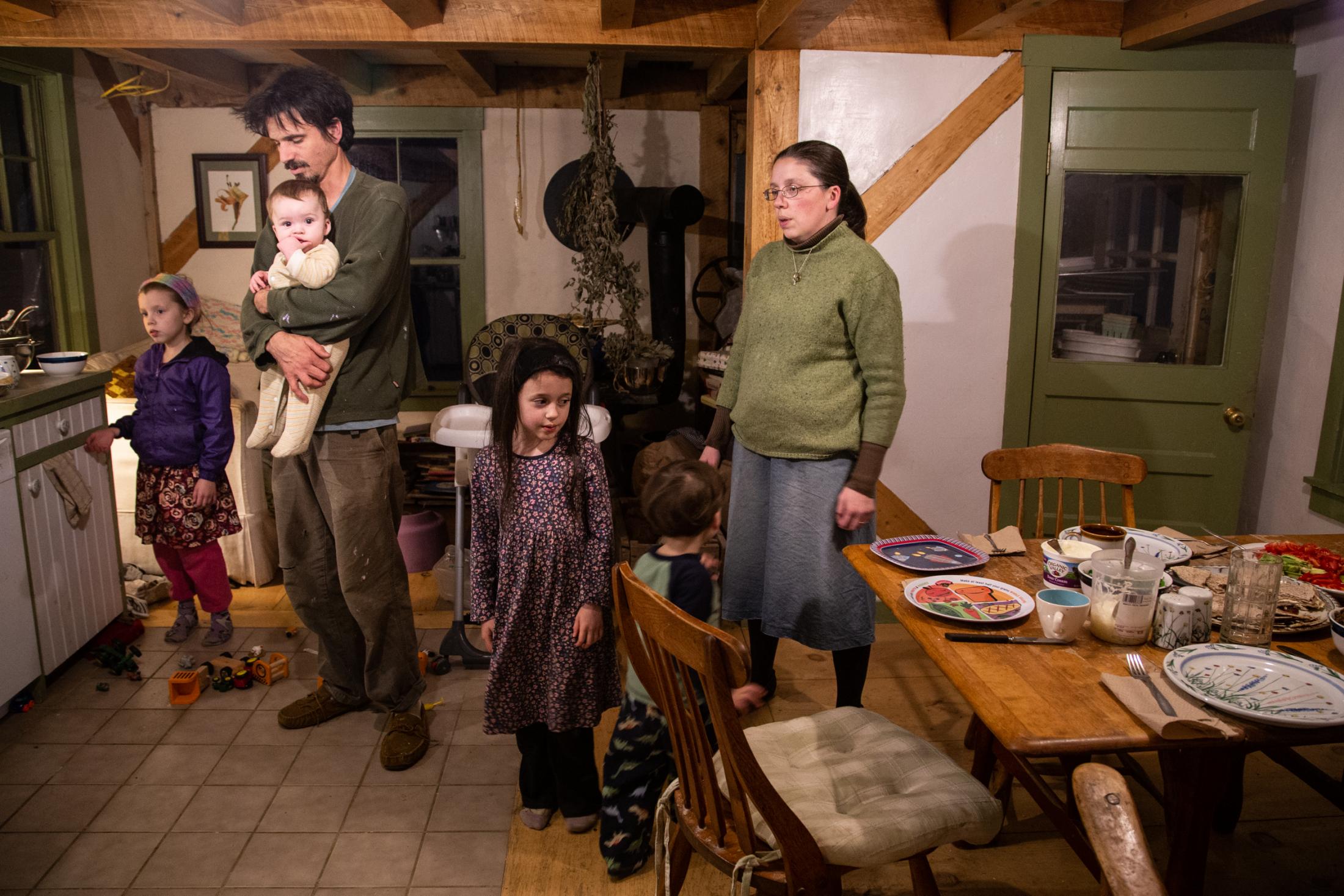 The family gathers for a prayer before dinner, Bremen, Maine, 2014.&nbsp;