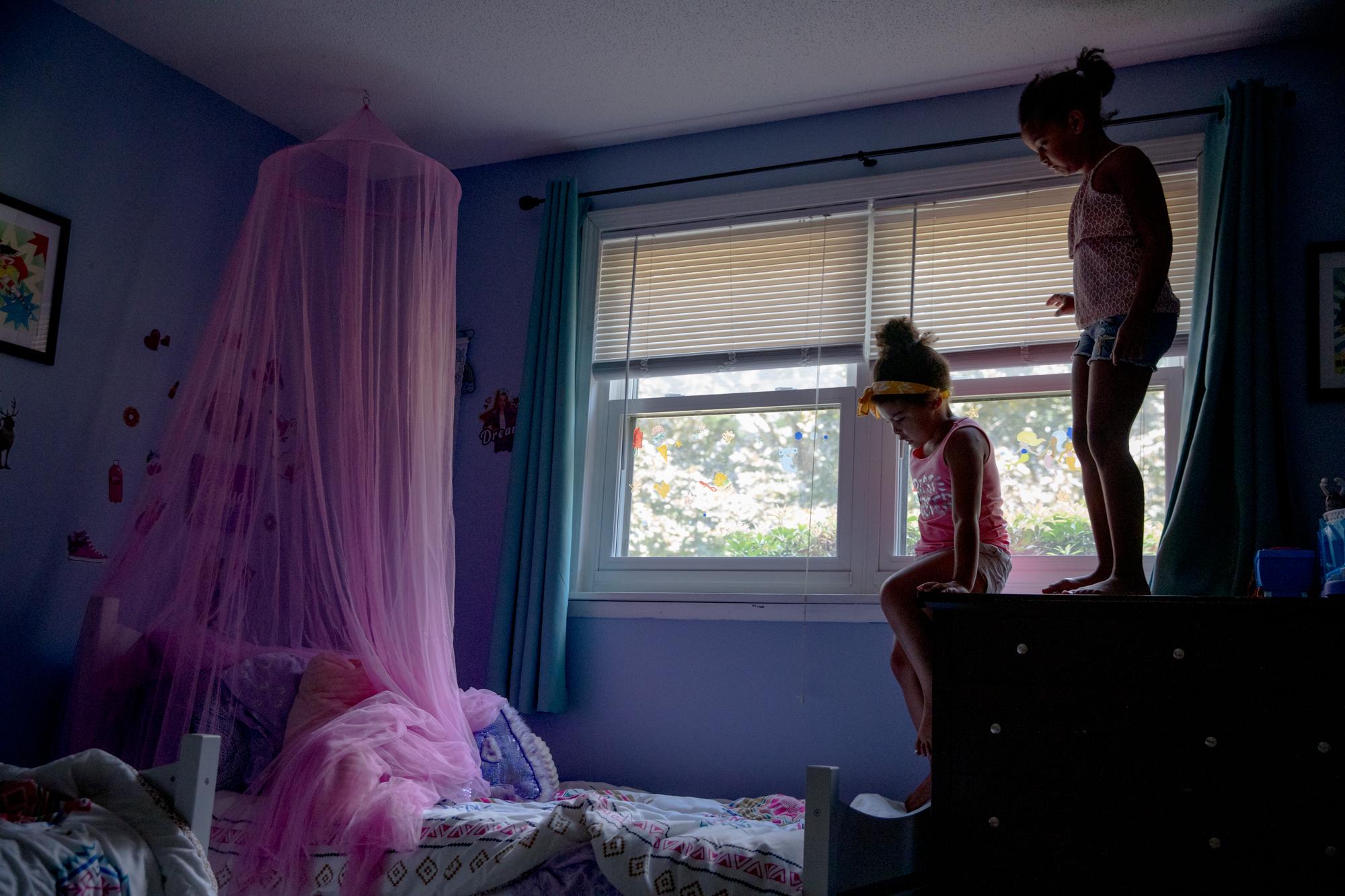 Juliet, left, and Anya hang out in their room while their mom, Tracey, works in her bedroom. The close age gap between the girls has been helpful during the pandemic, Tracey said. &ldquo;We&rsquo;re all just becoming closer because we&rsquo;re getting to spend even more time together, which I think is one of the benefits of this too. Just getting to slow down and enjoy them.&rdquo;