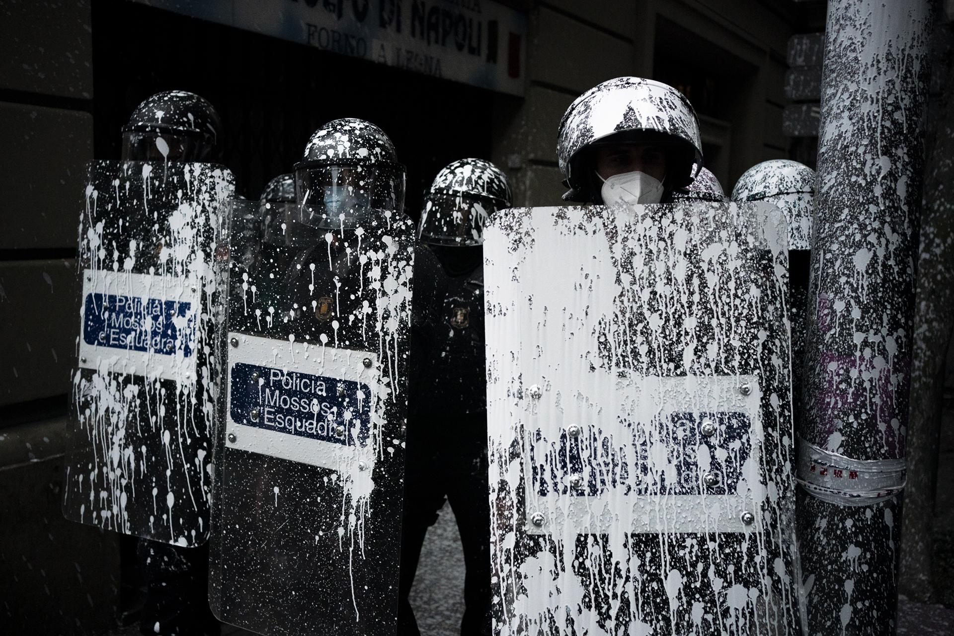 Barcelona Housing Crisis (ongoing) - Riot police officers covered by paint thrown by...