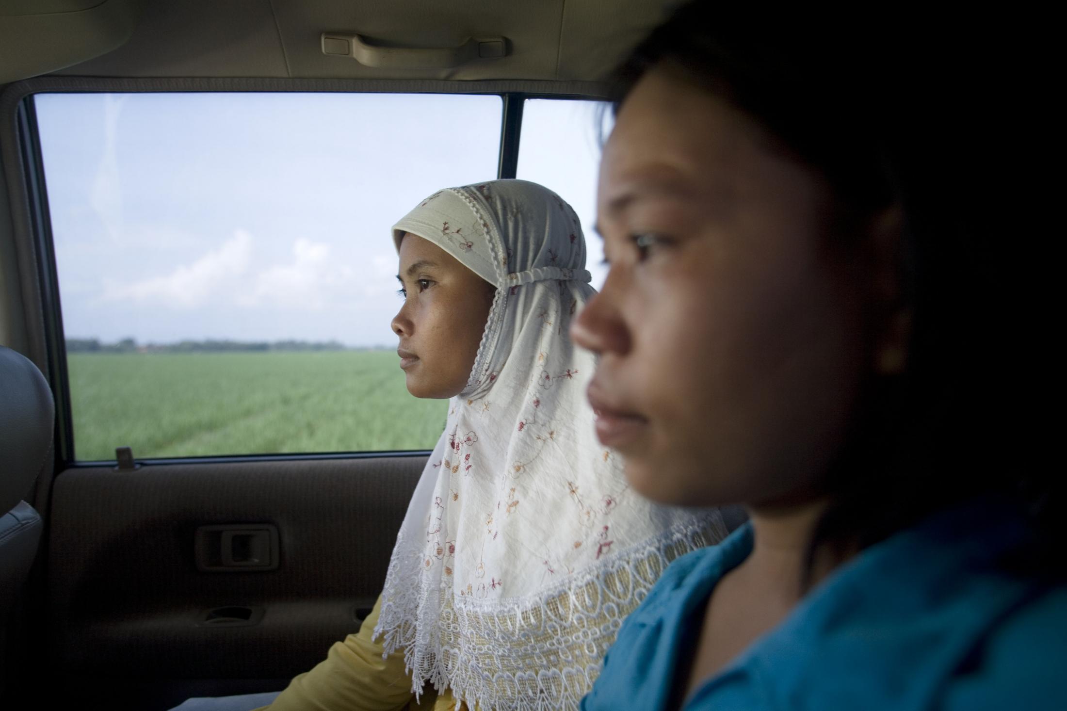 Sari, 28, and Nuryani, 20, begin their journey to a labor recruitment agency in Jakarta to be...