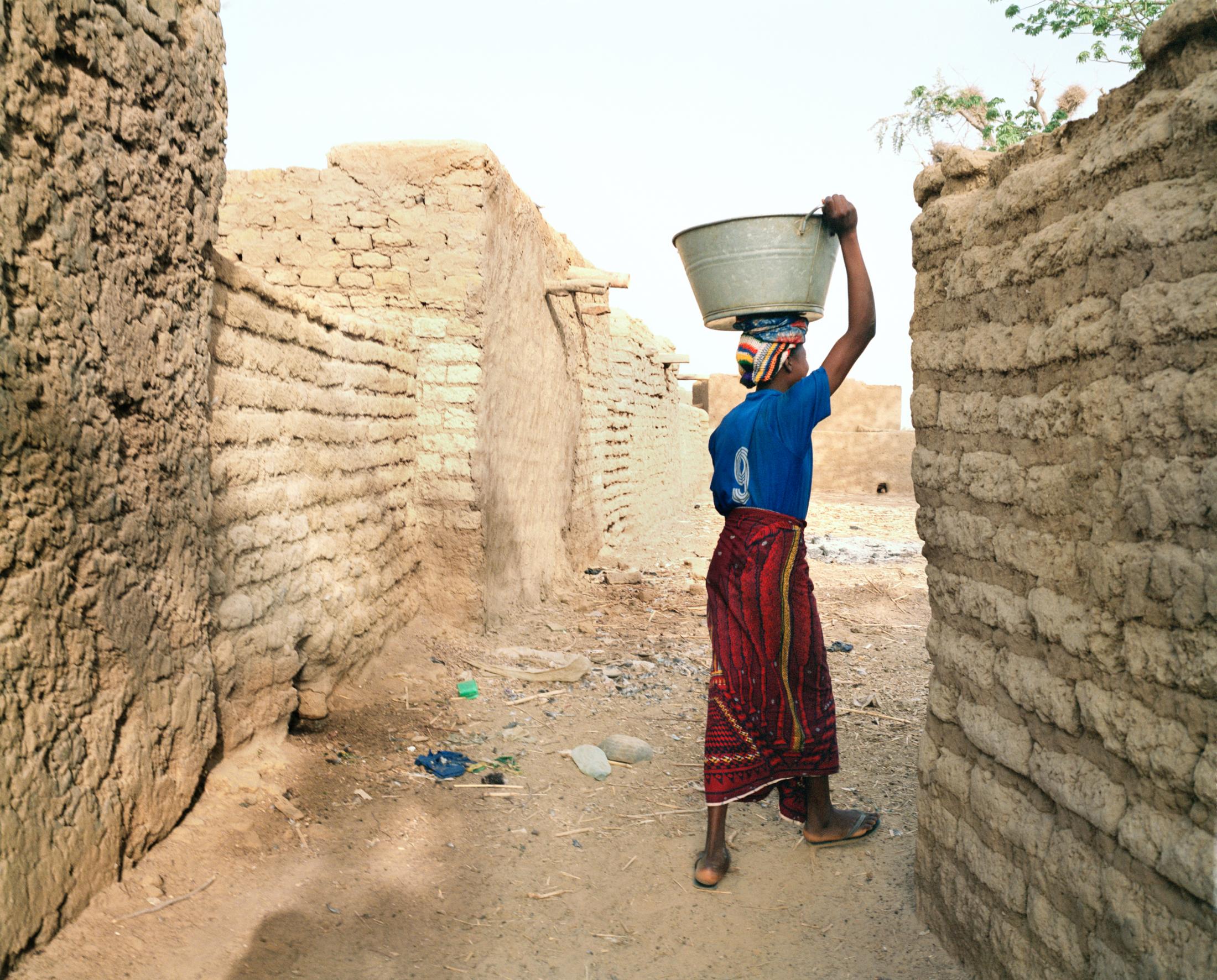 Mariam heading to the community water pump. Tinto, Mali. 2007.