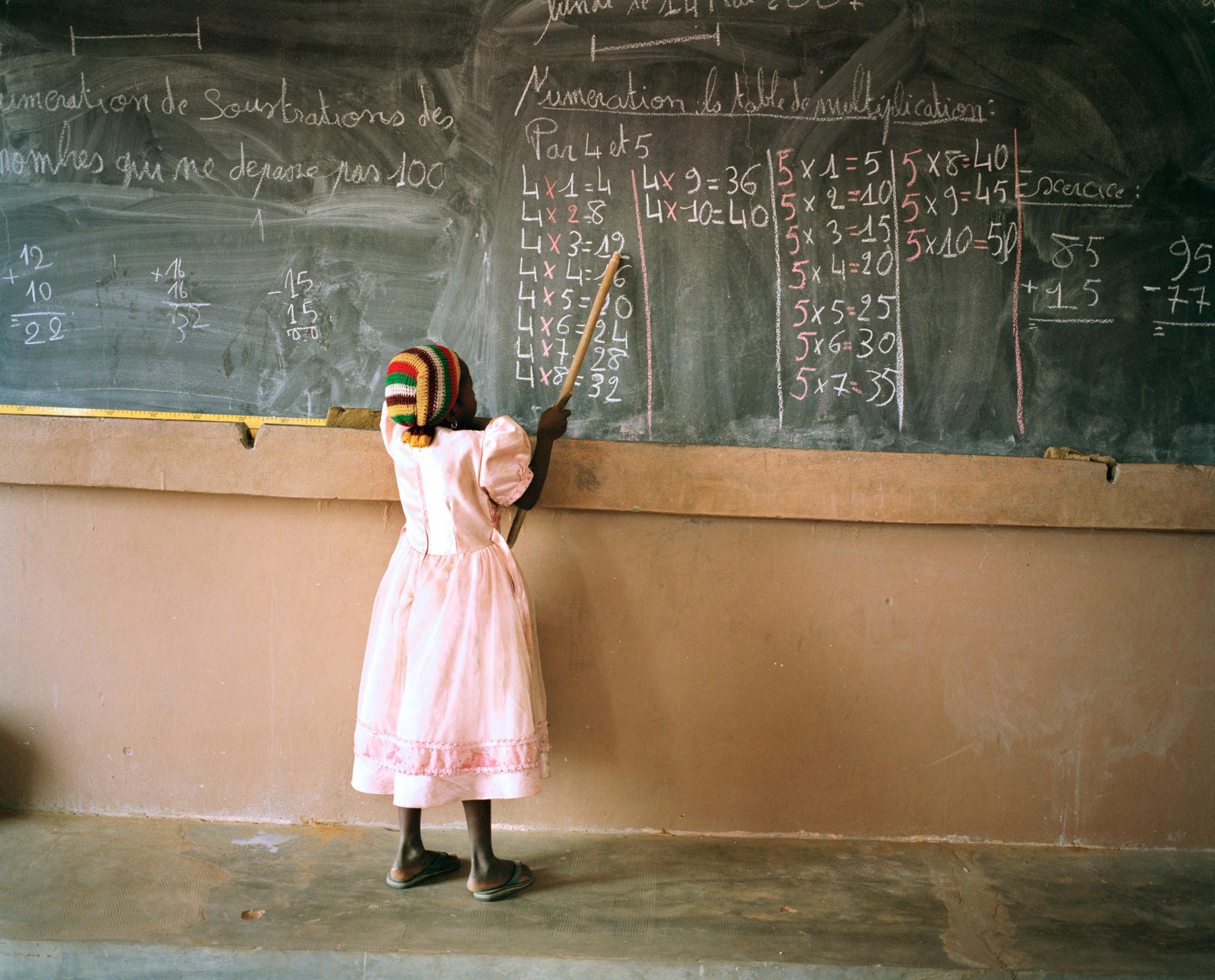 First grader begins to learn numbers in village school. Tinto, Mali. 2007.