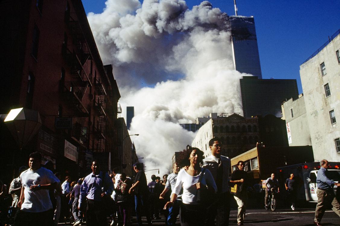 Pedestrians on Church Street run from falling debris as Tower 2, the South Tower, of the World...