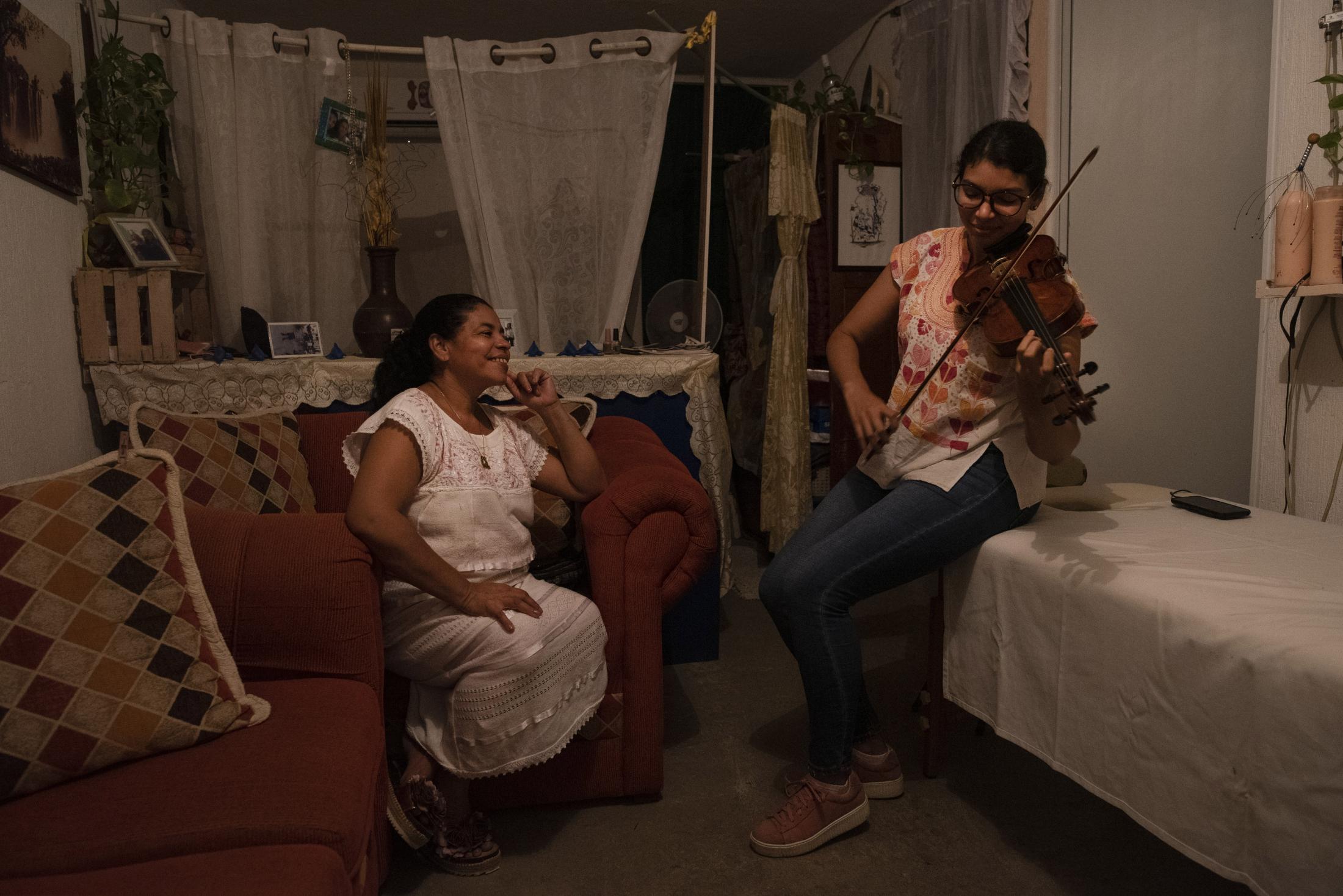 Mujeres ante la pandemia: Paola - Paola Reyes observa a su hija Astrid Rodriguez tocar una...