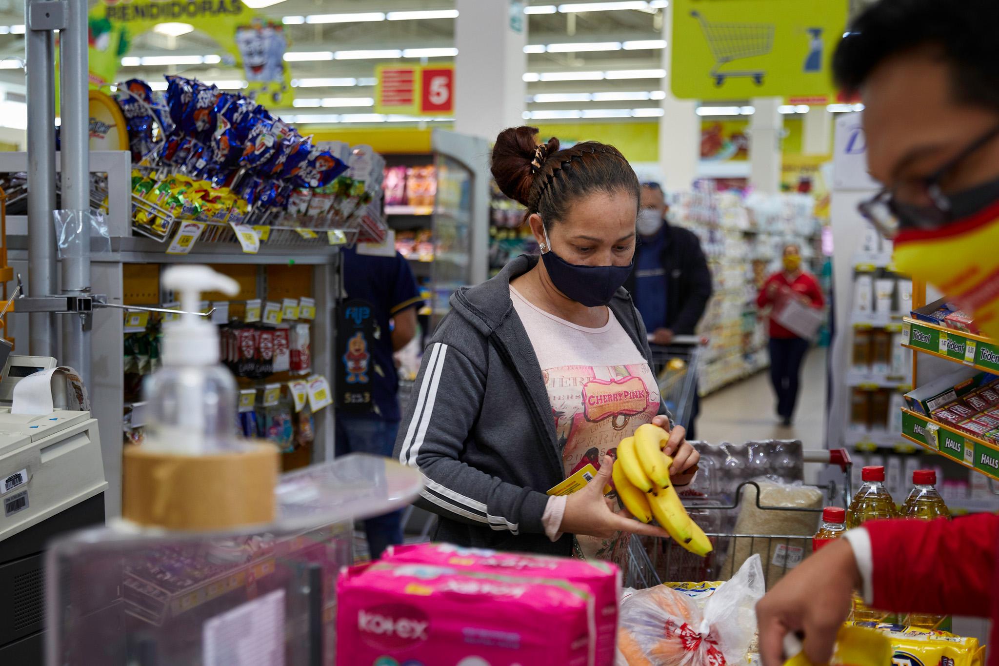 Plan International - ESP: Una mujer migrante recorre el Supermercado Santa...