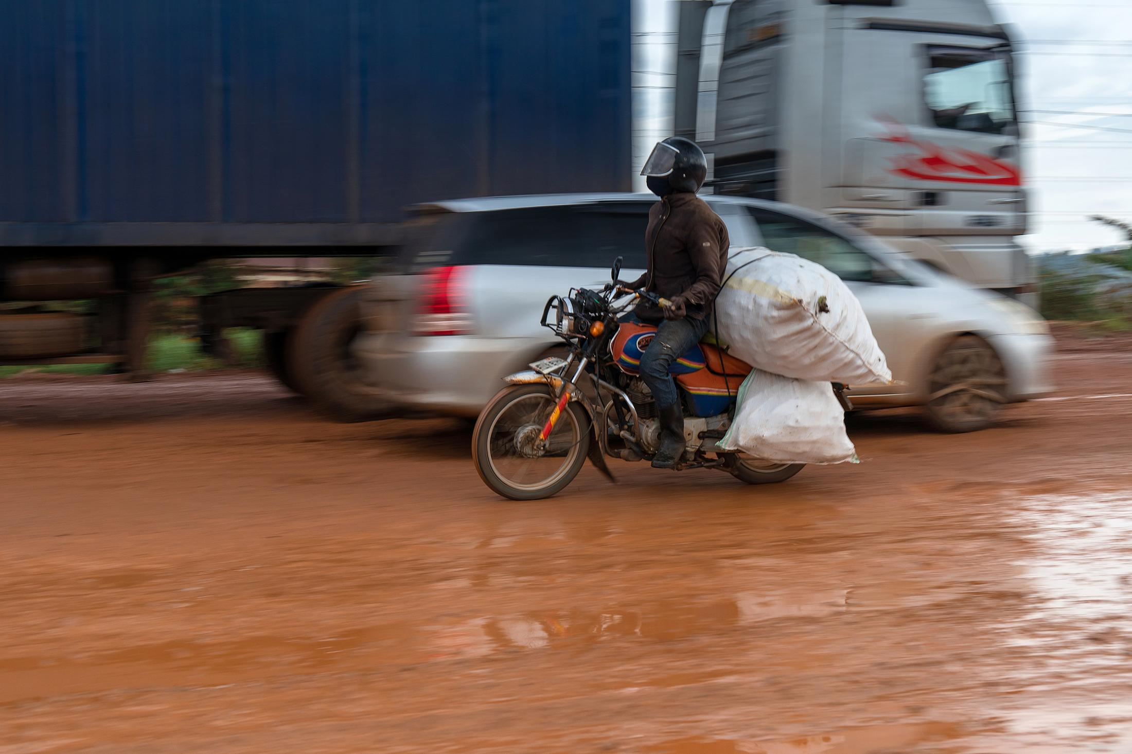 Domestic Express - Speeding Boda delivering merchandise on a rainy day.