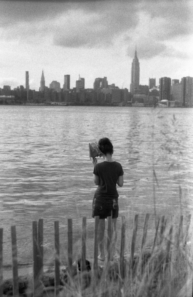 A girl overlooking the East River from Williamsburg.