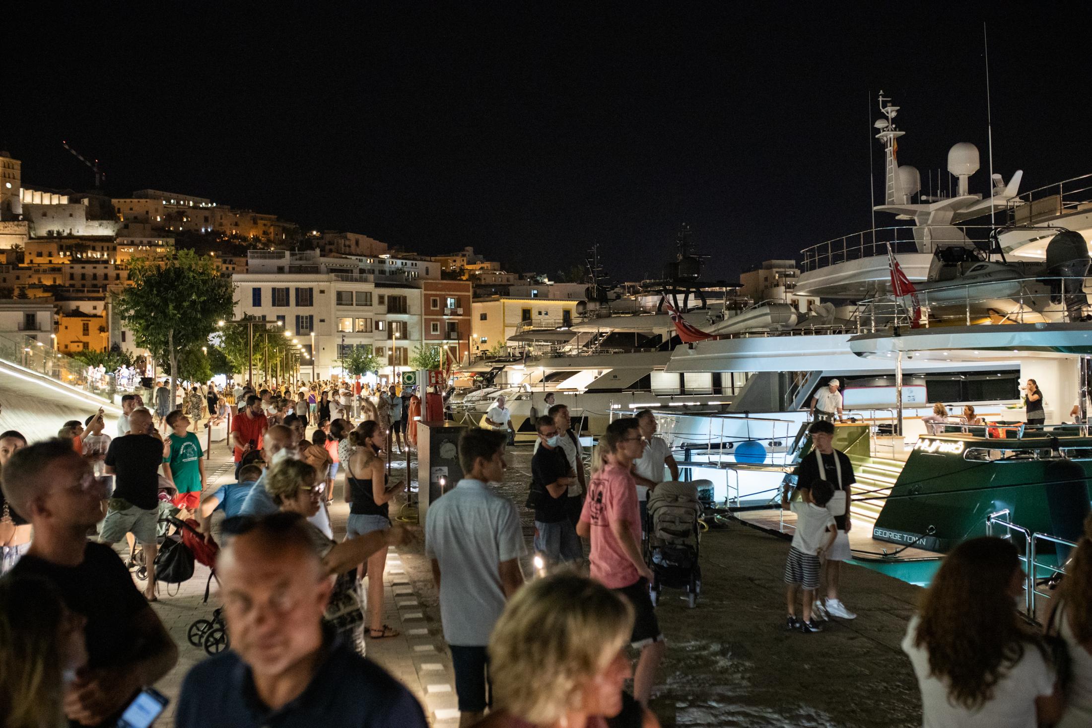 Covid-19: Ibiza Parties Infiltrated By Detectives - IBIZA, SPAIN - AUGUST 6: Tourists watch luxurious yachts...