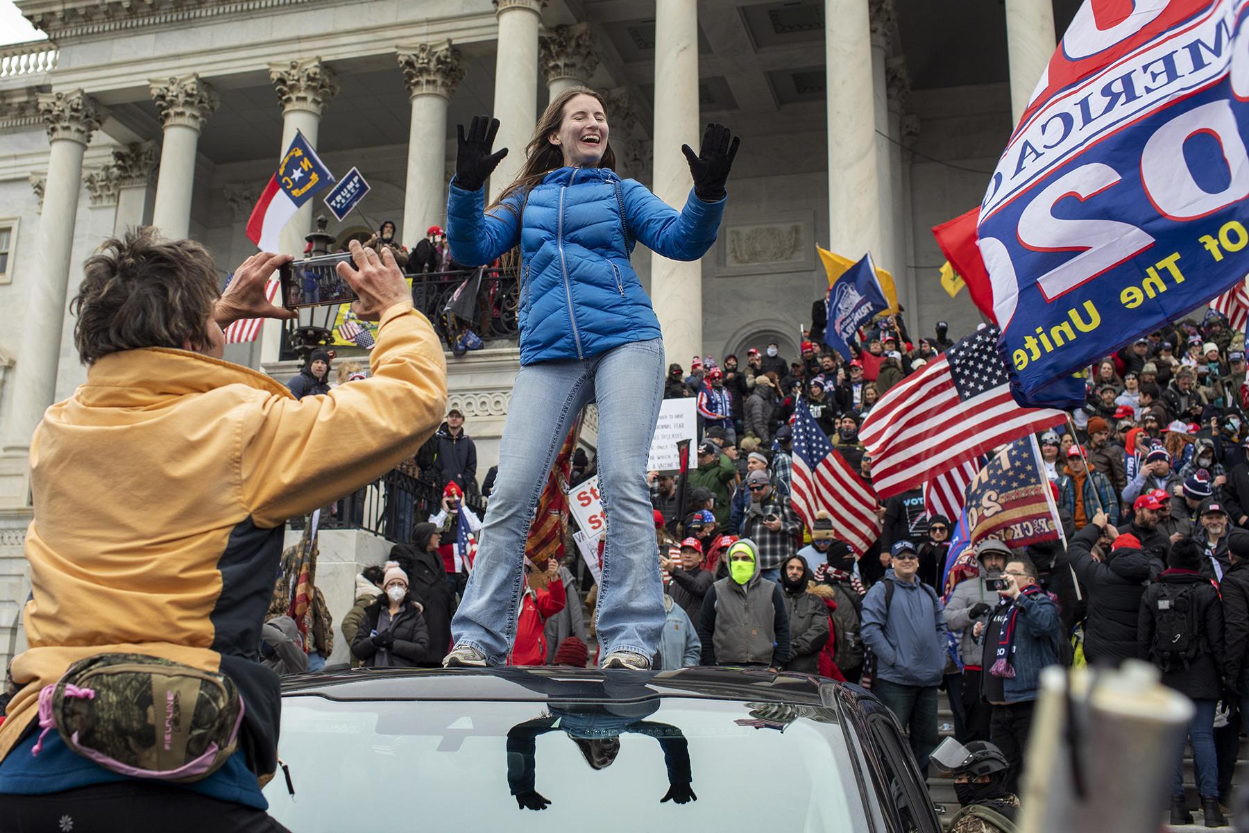 Protests, Pestilence & Politics - A woman dances on top of an SUV on the east side of the...