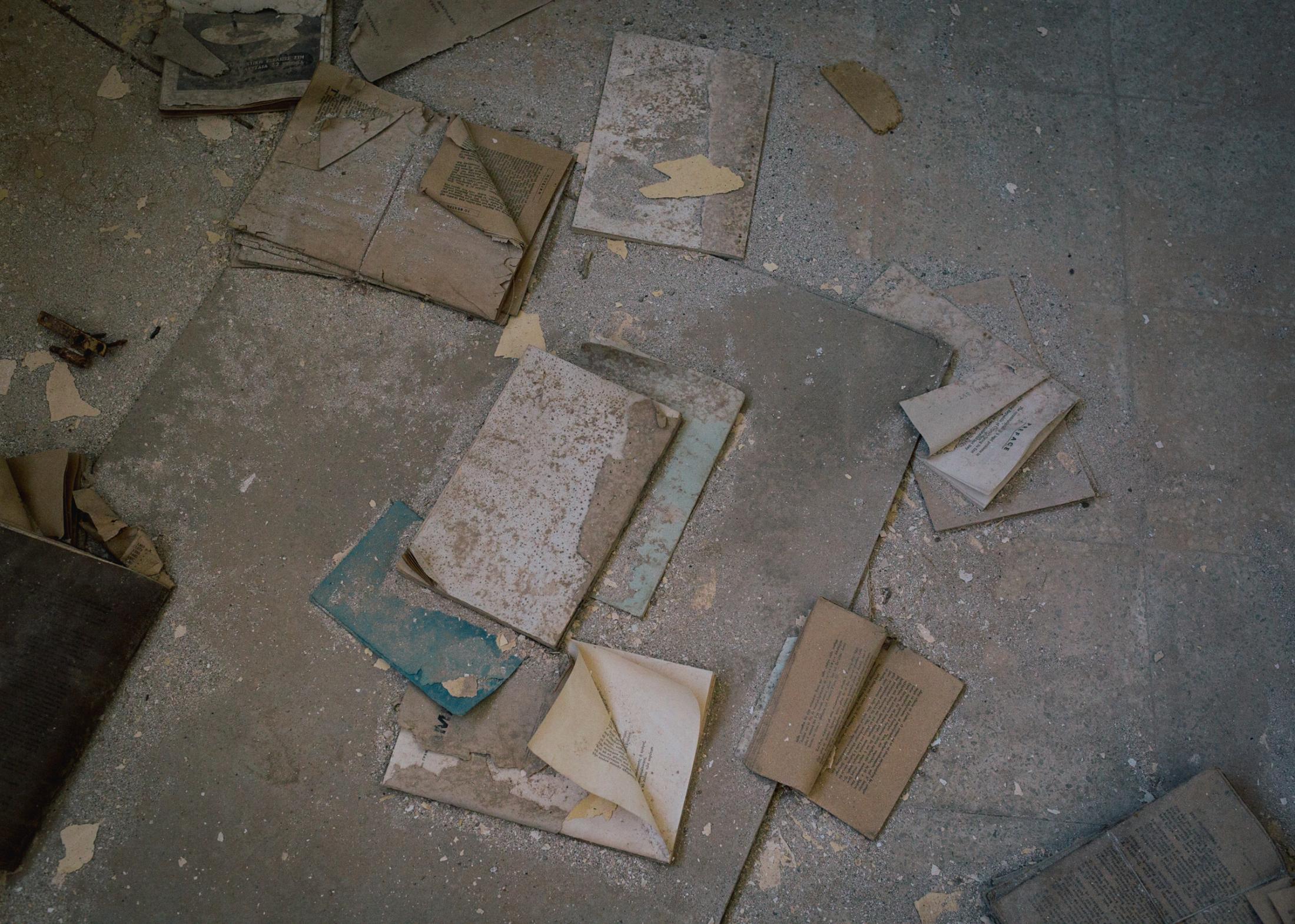 Books lie scattered on the floor in the former library in the ghost town.
