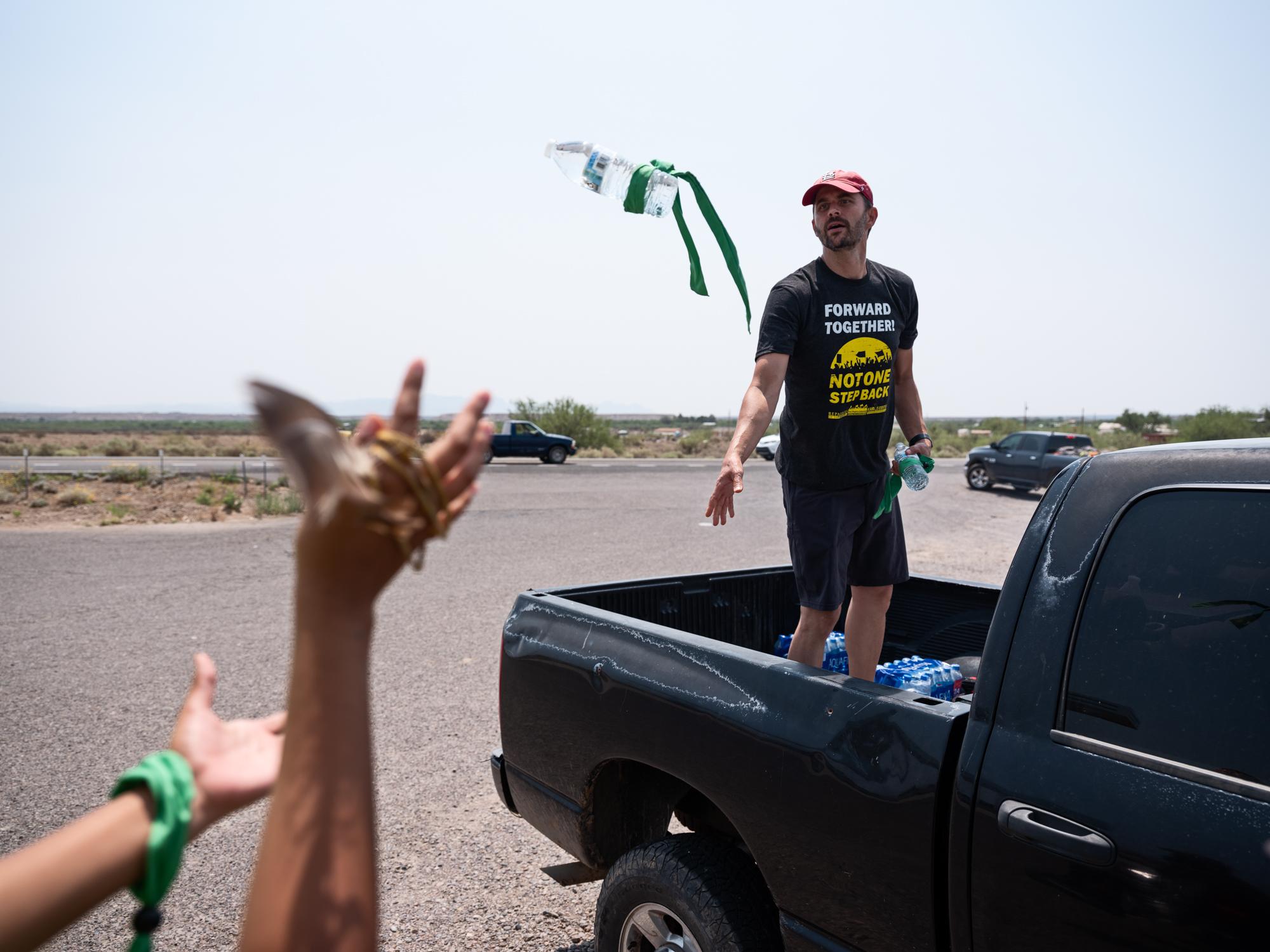30 Years Running - High Country News - Adam Barnes tosses a water bottle to another runner. The...