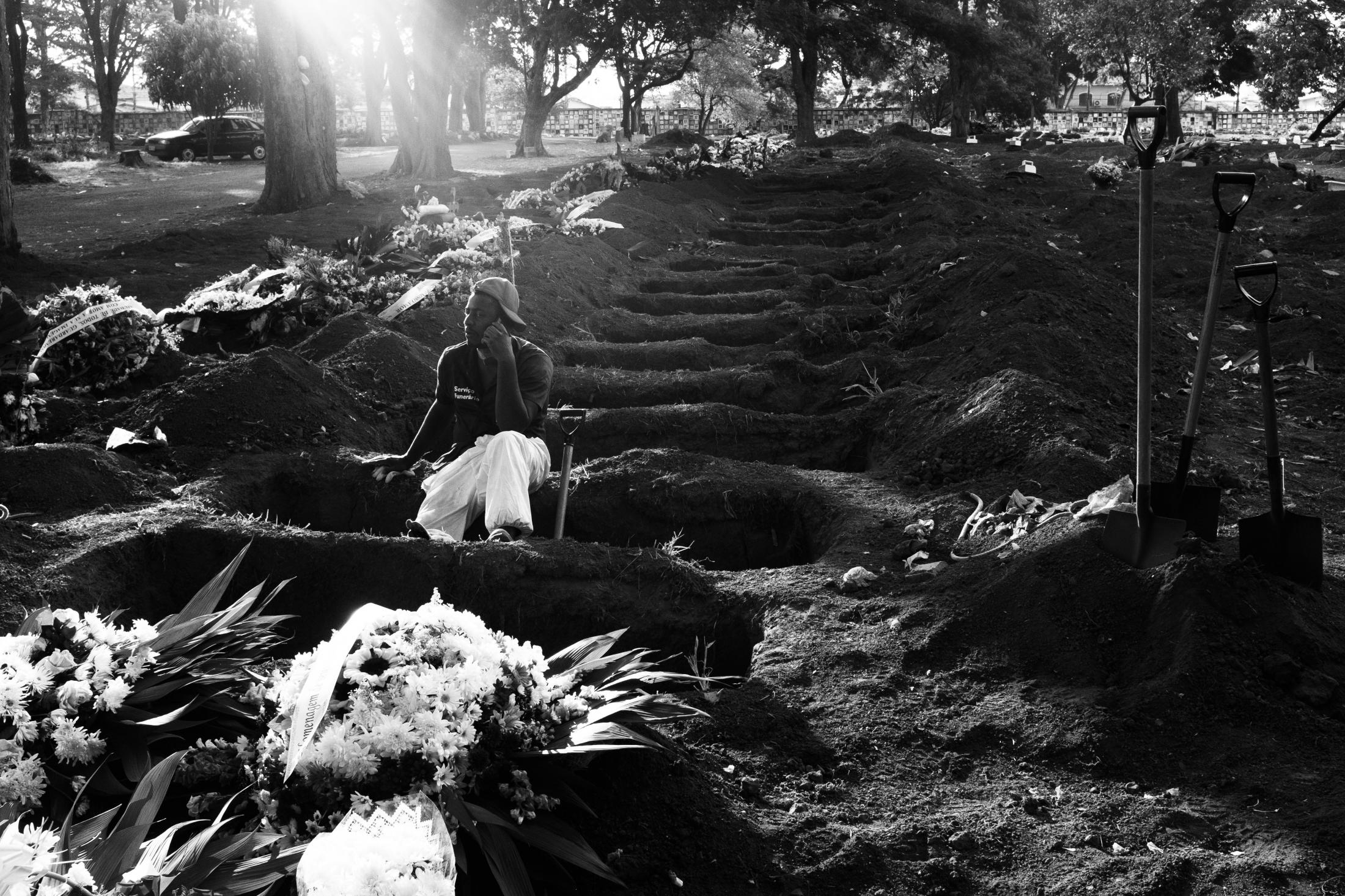 A Vaccine for the World - A gravedigger rests in an opened grave at Vila Formosa cemetery, the biggest cemetery in Latin...