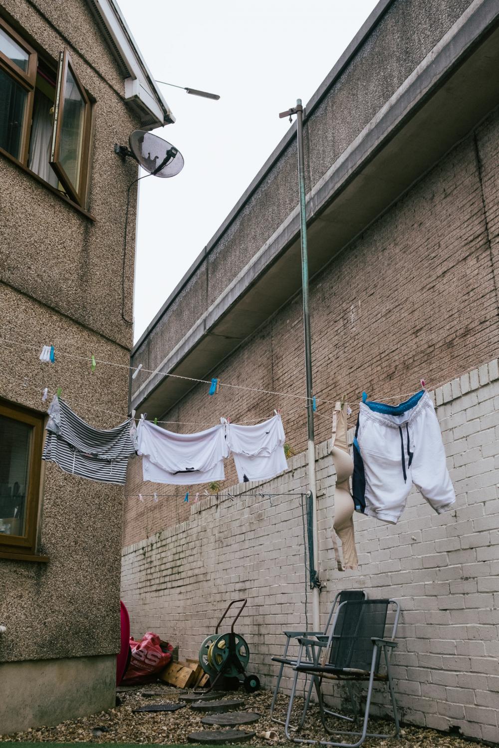 A clothes line attached to the reinforcement wall of the M4 motorway, in the back yard of a house...