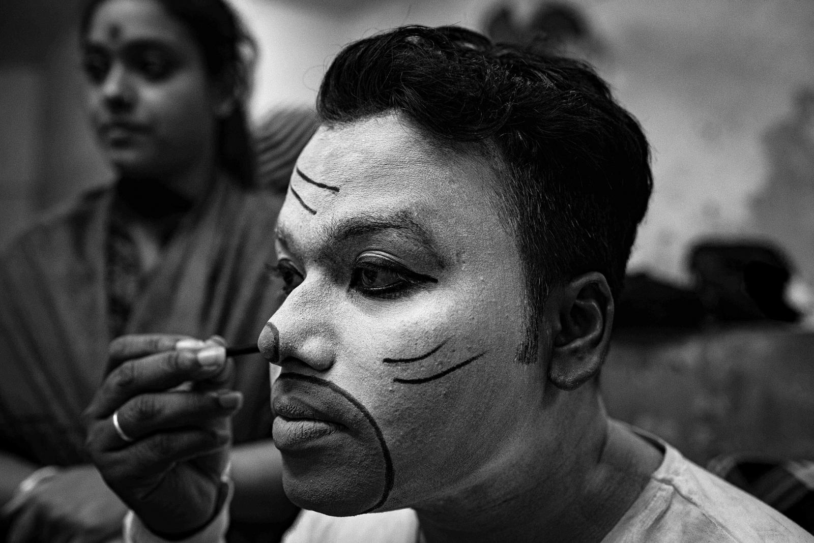 A performer taking makeup as per his role in the drama.