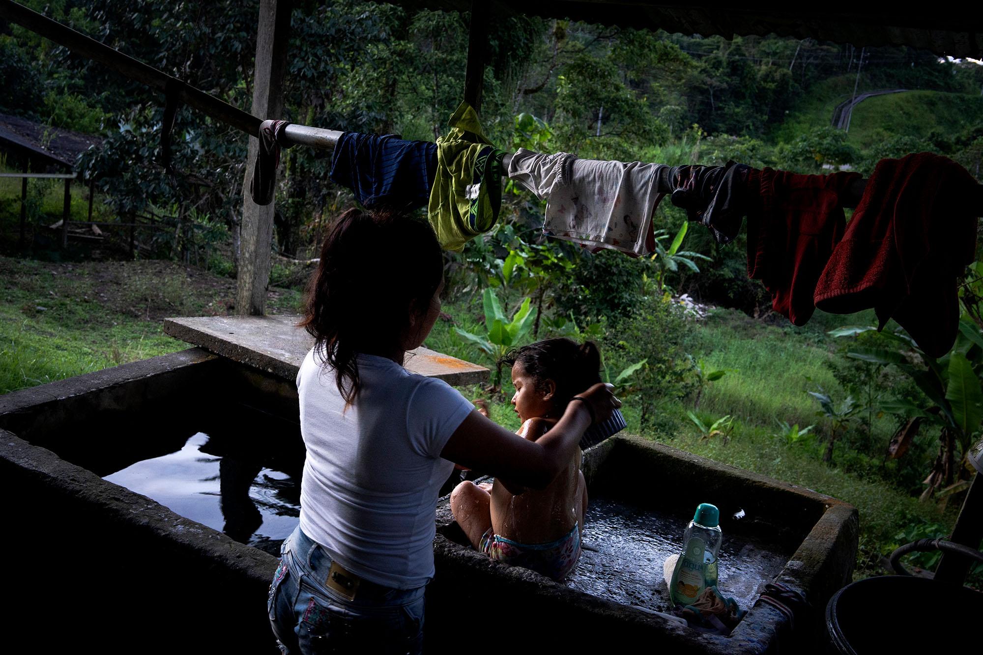 A mother bathes her daughter on the afternoon of April 28, 2021. Families in the community of San...