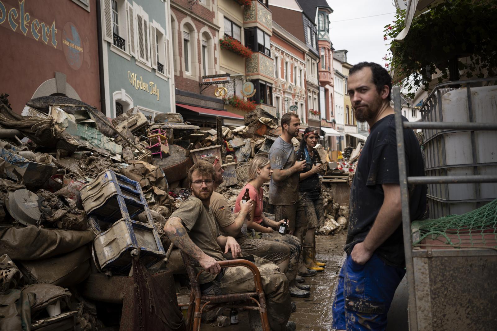 Image from SINGLES - People take a break from cleaning the debris from the...