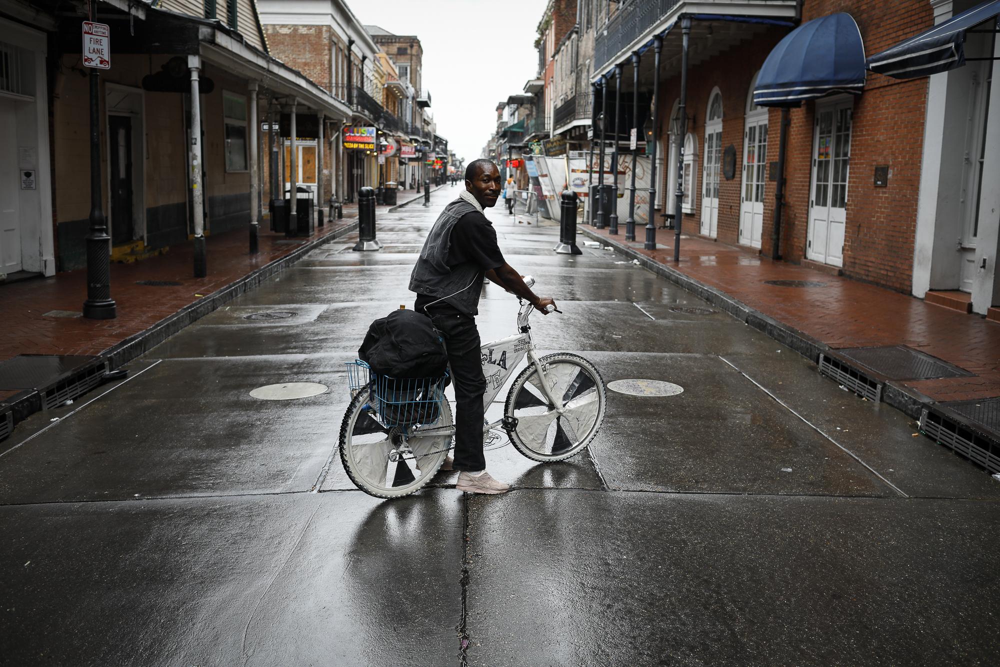 Hurricane Ida in Louisiana - A man rides a bicycle in Bourbon Street at the French...