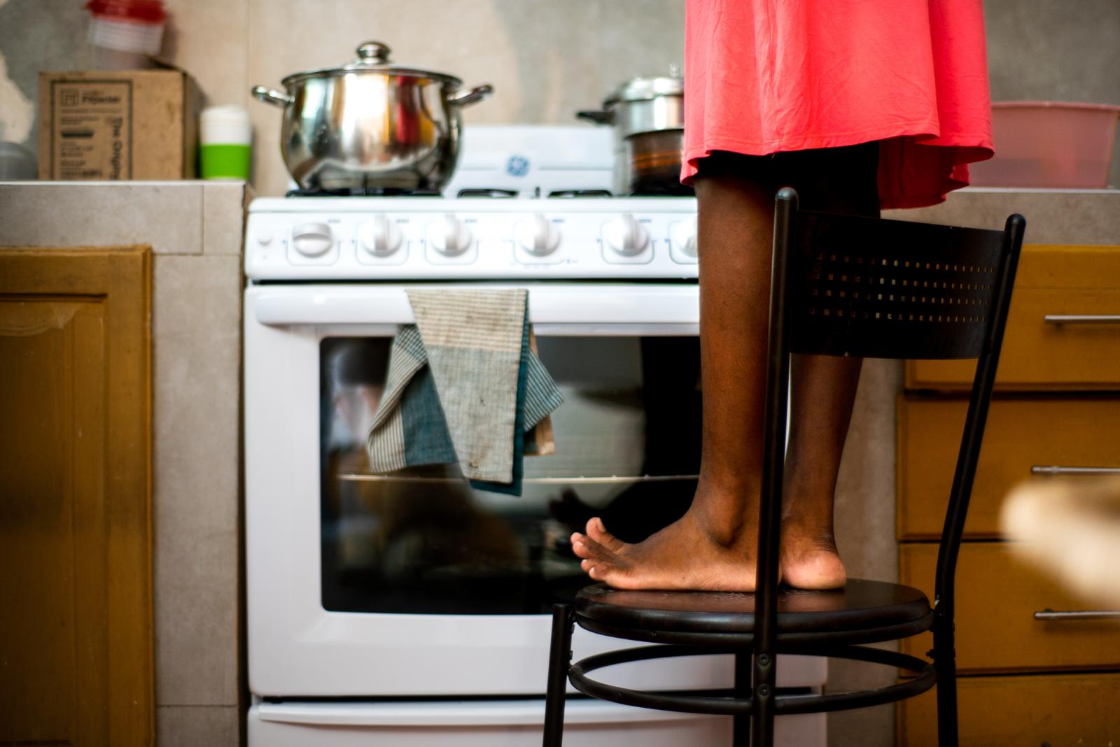 Youvelyne Rozier, 35, cooks her...pices as she helps cook dinner.
