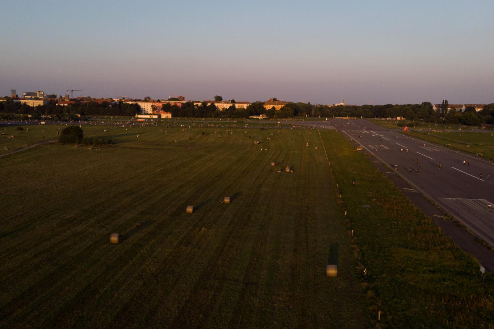 Hay bales glow in the fall evening sun on Berlin&#39;s former airport-turned-park Tempelhofer Feld. Taken with a drone, September 8, 2021.