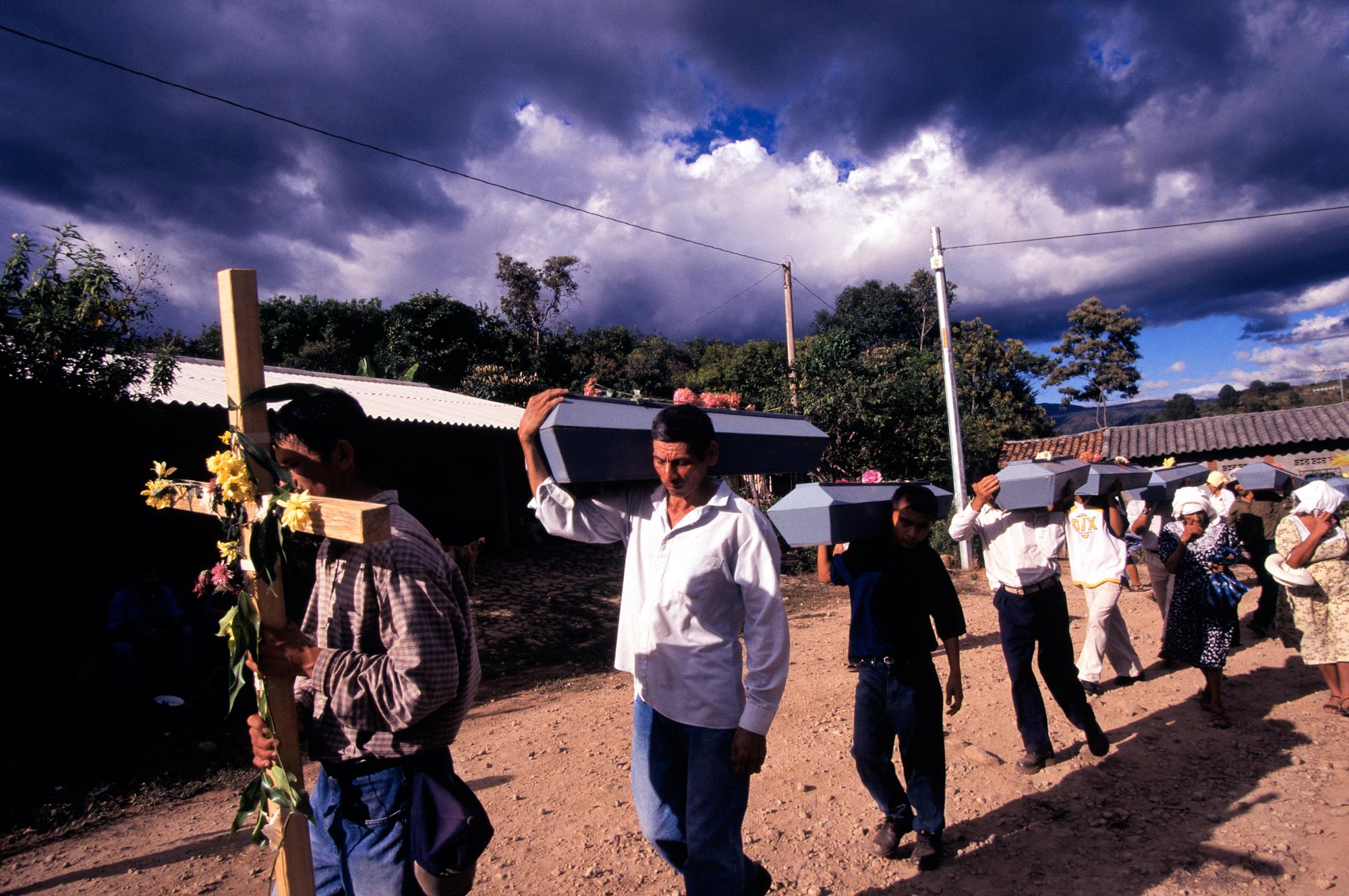 El Salvador Anniversary - Family members carry the coffins with exhumed remains...