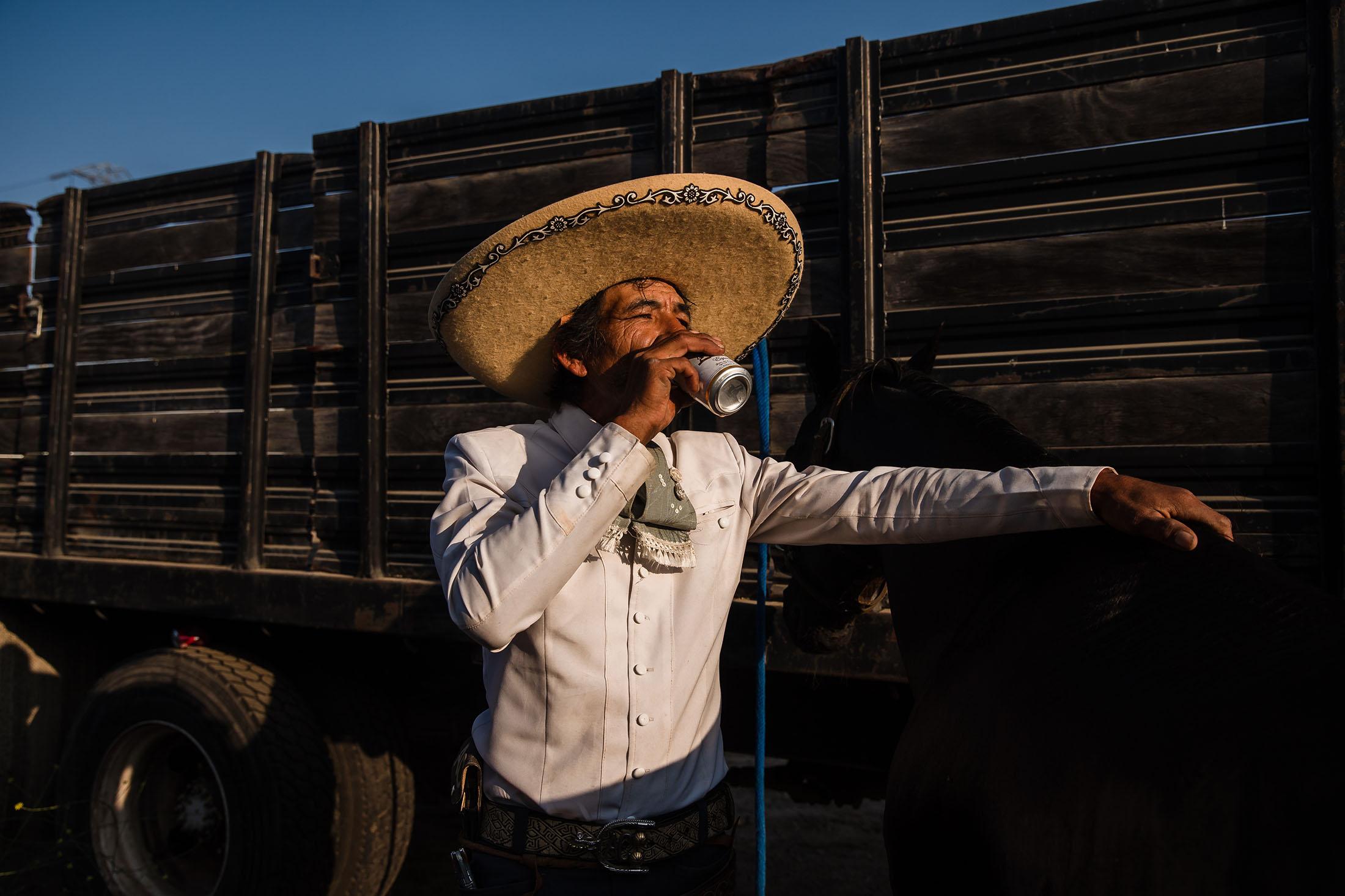 Casimiro Castillo, a member of the Charros Rancho La Laguna team drinks a beer after a charrer&iacute;a competition at Pico Rivera Sports Arena in Pico Rivera, California on July 16, 2021.