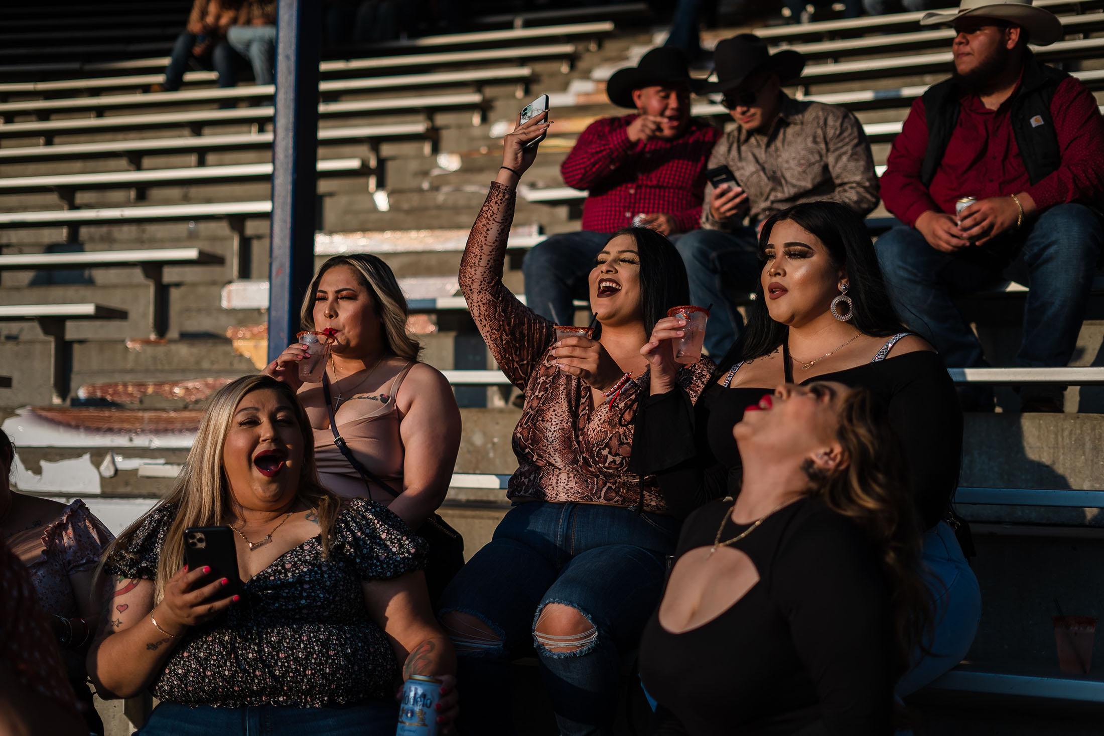 People sit in the bleachers after the charrer&iacute;a competition at Pico Rivera Sports Arena in Pico Rivera, California on July 16, 2021. After the competition many gathered listening to live music and danced.